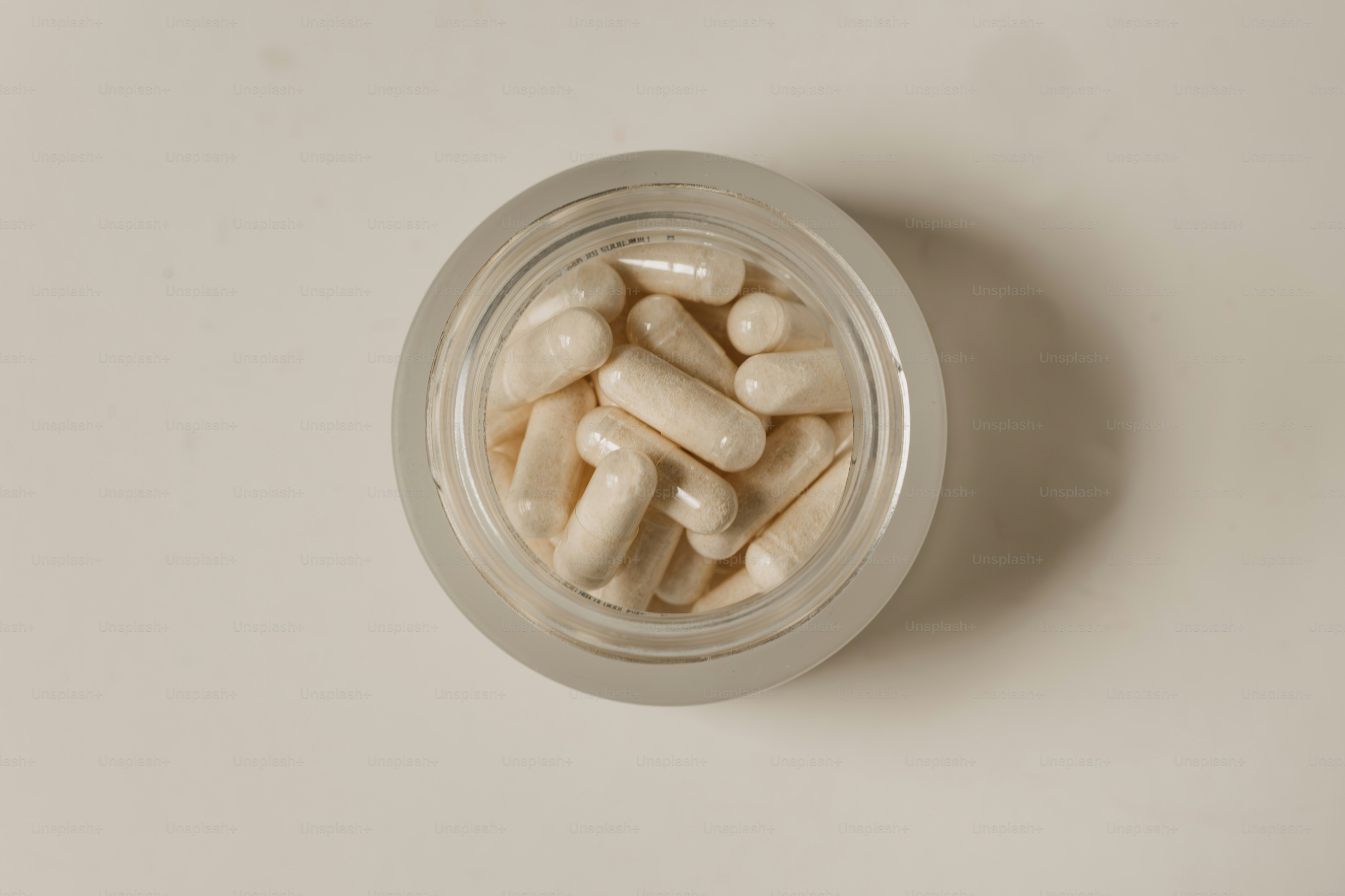 A jar filled with white pills sitting on top of a table