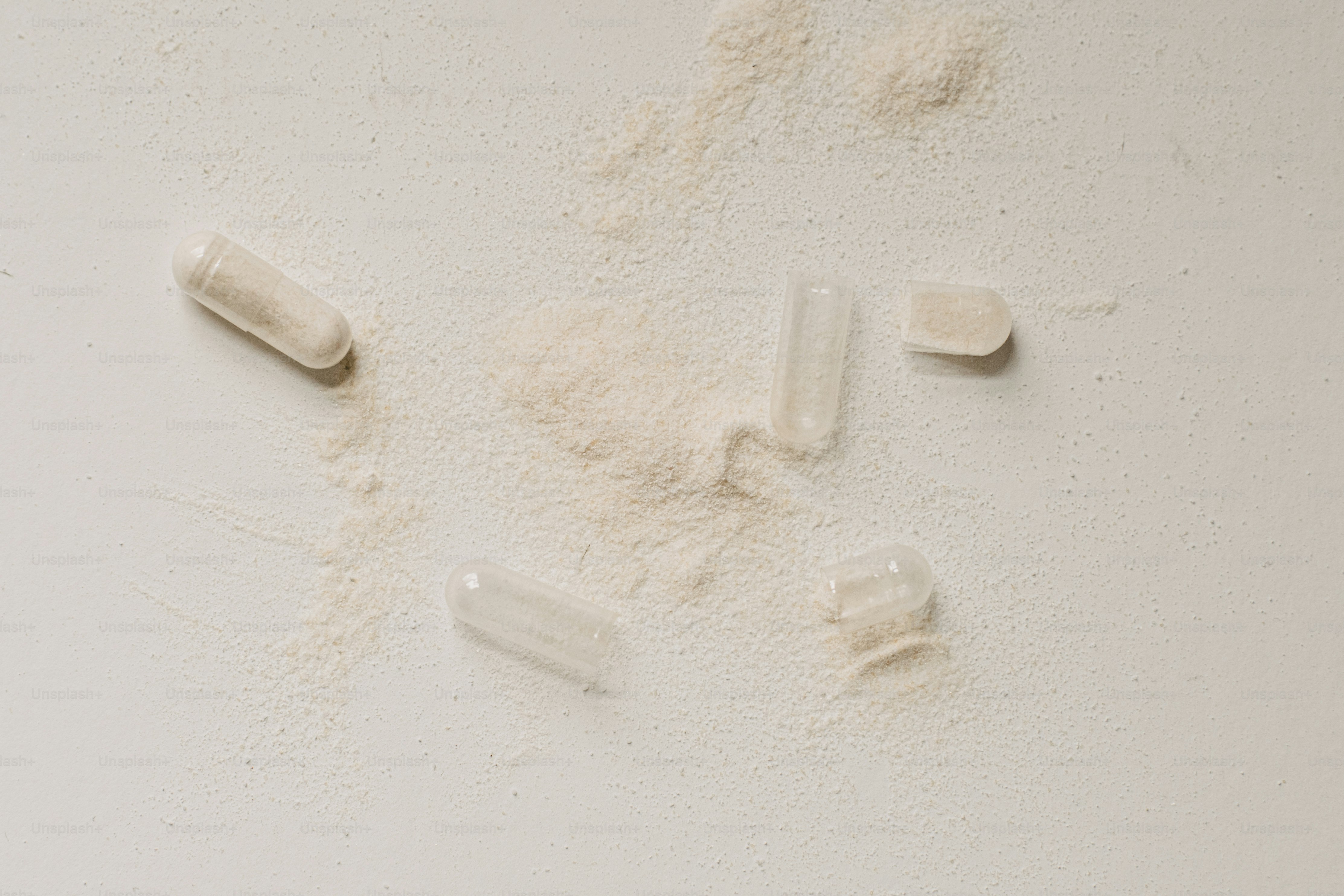 A group of pills scattered on a white surface