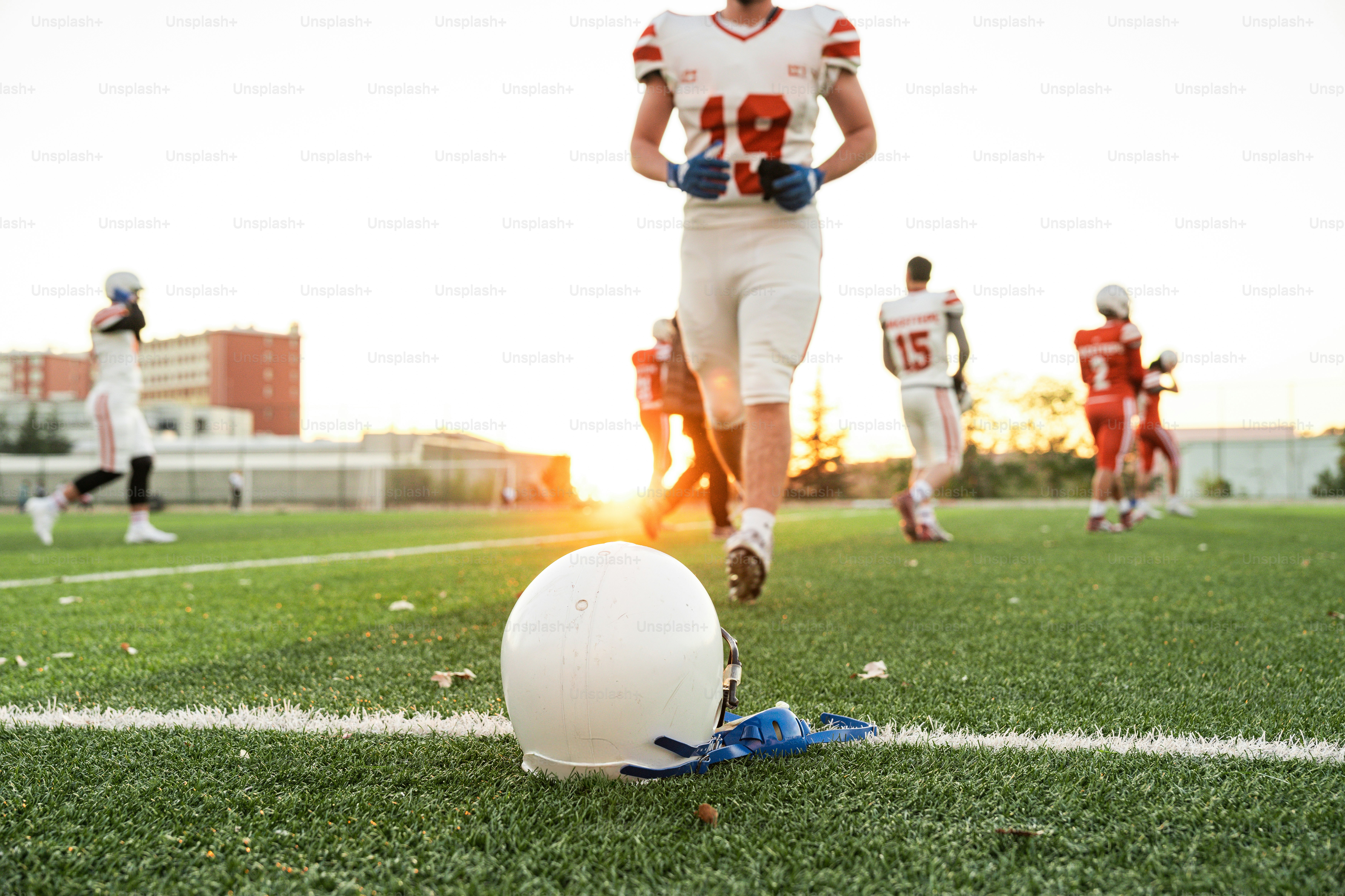 A football player running towards a ball on a field
