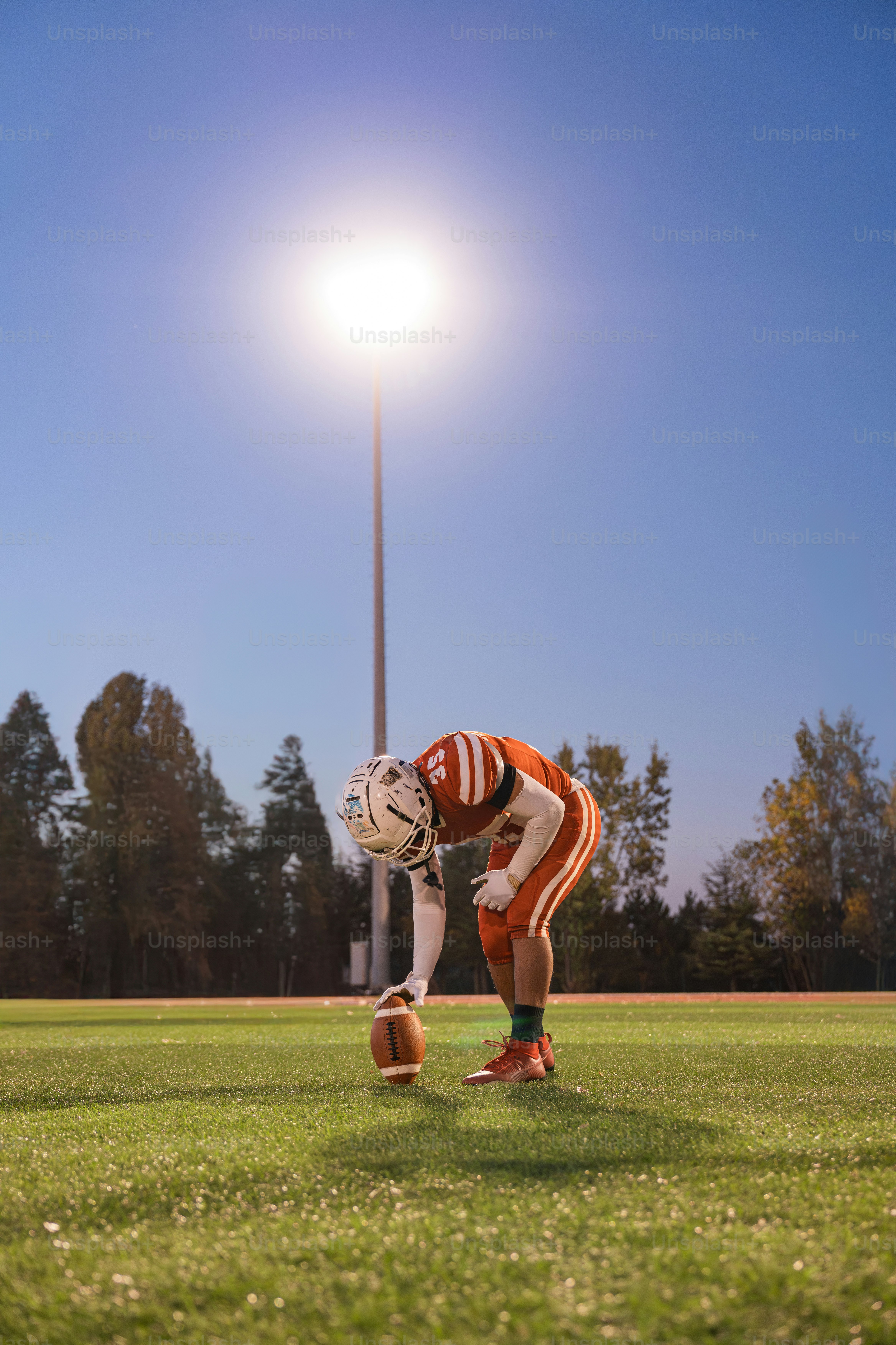 A football player kneeling down on a field