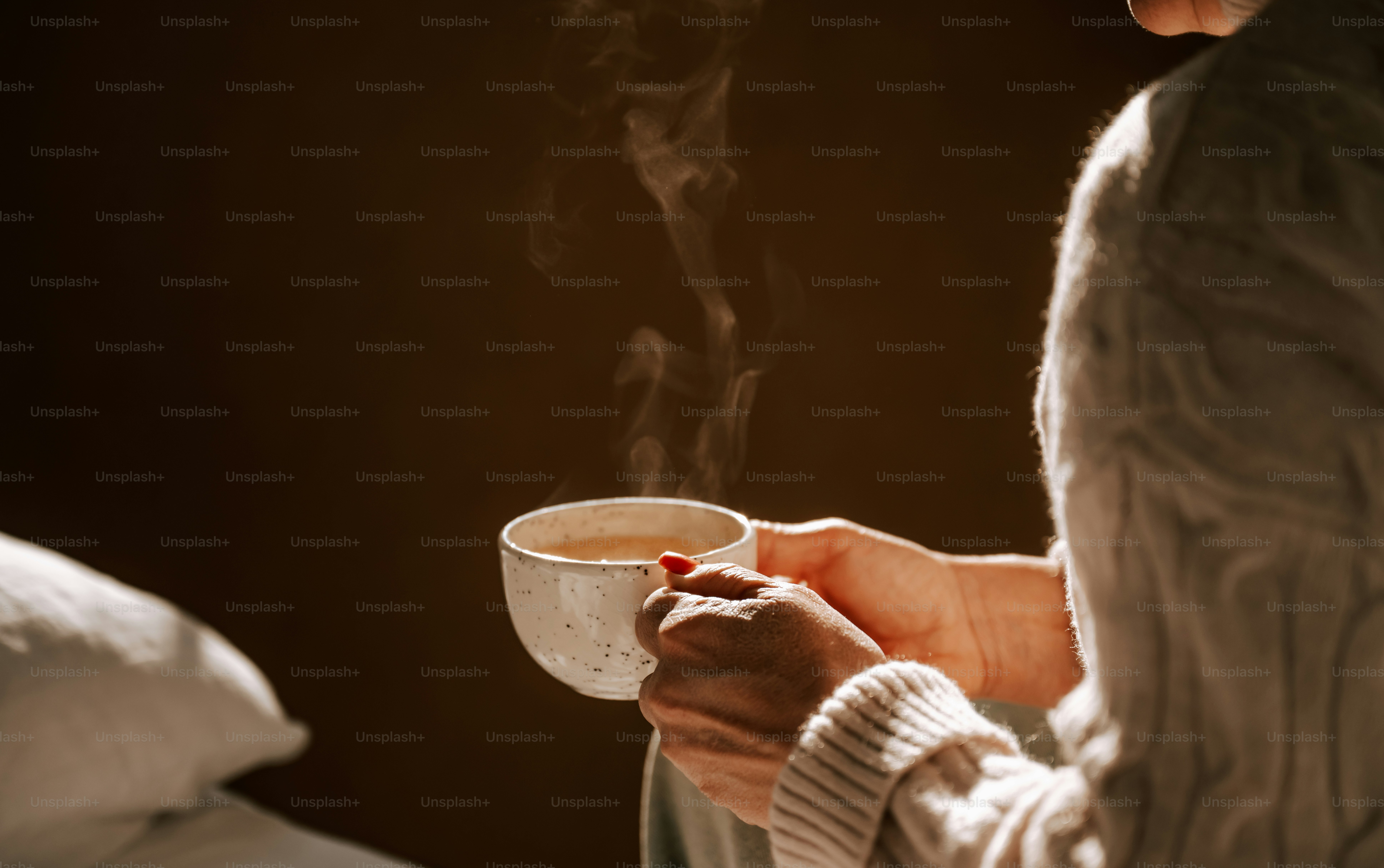 A woman is holding a cup of coffee