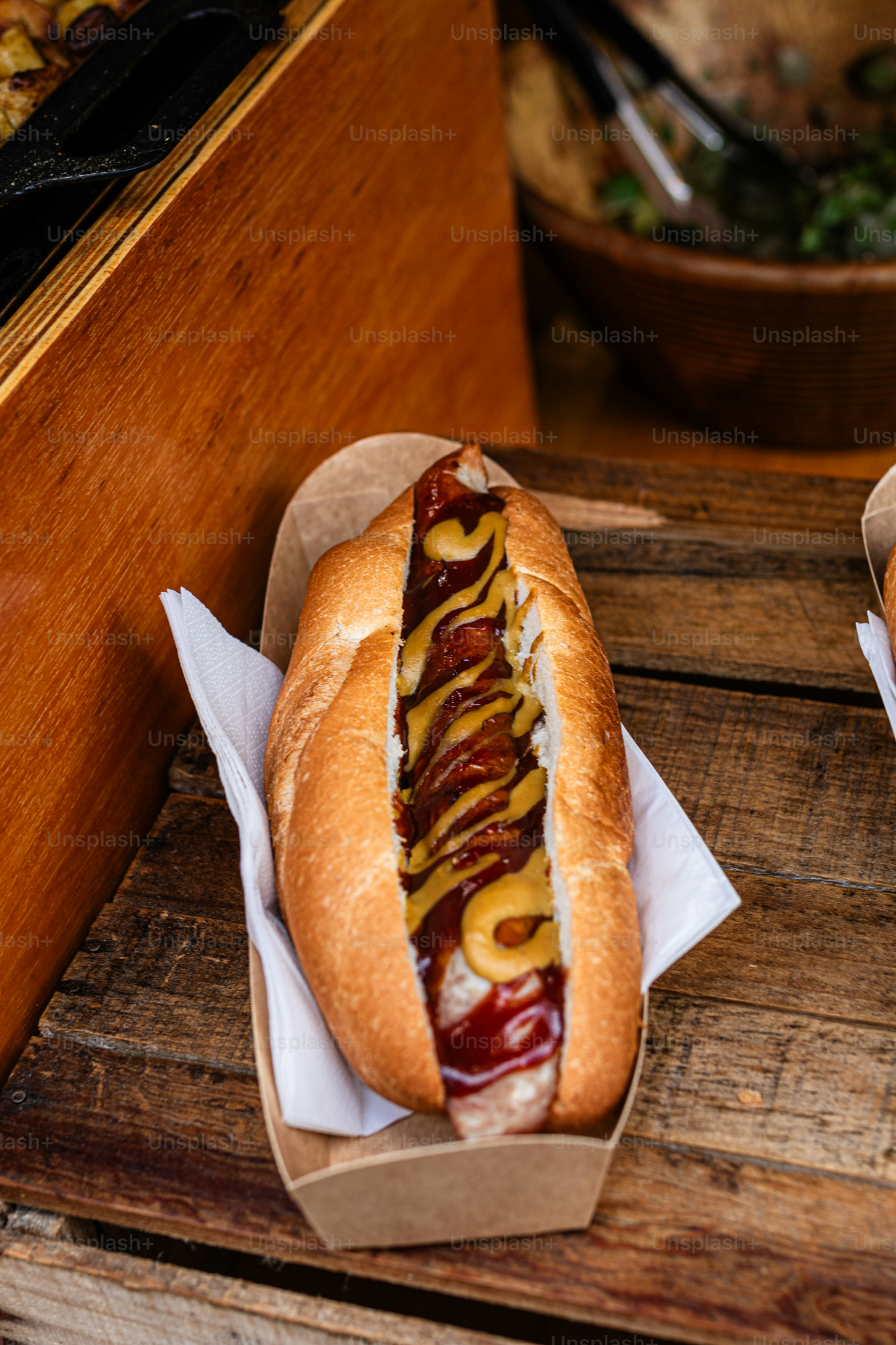 Zwei Hotdogs mit Senf und Ketchup auf einem Holztisch