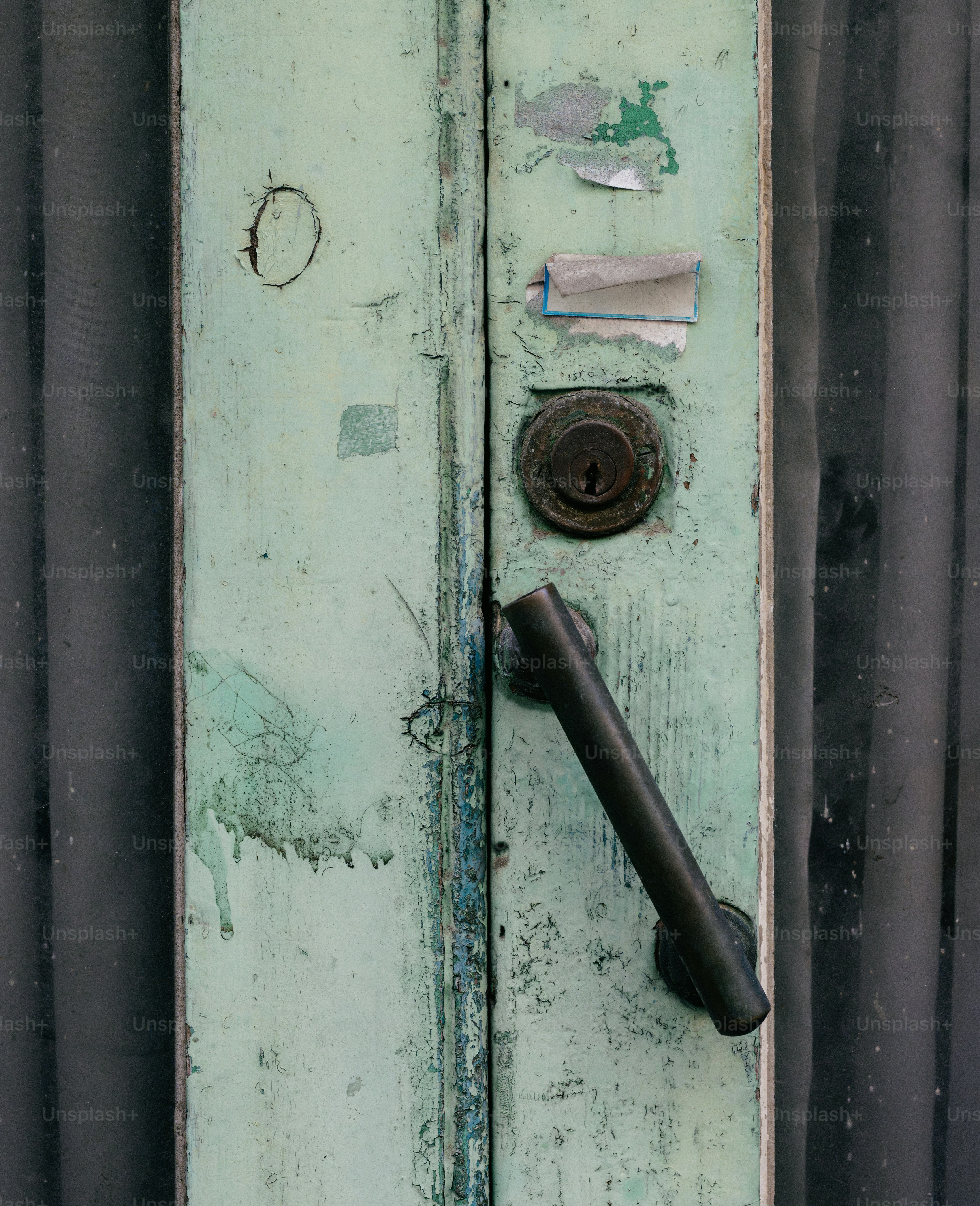 A green door with a black handle on it