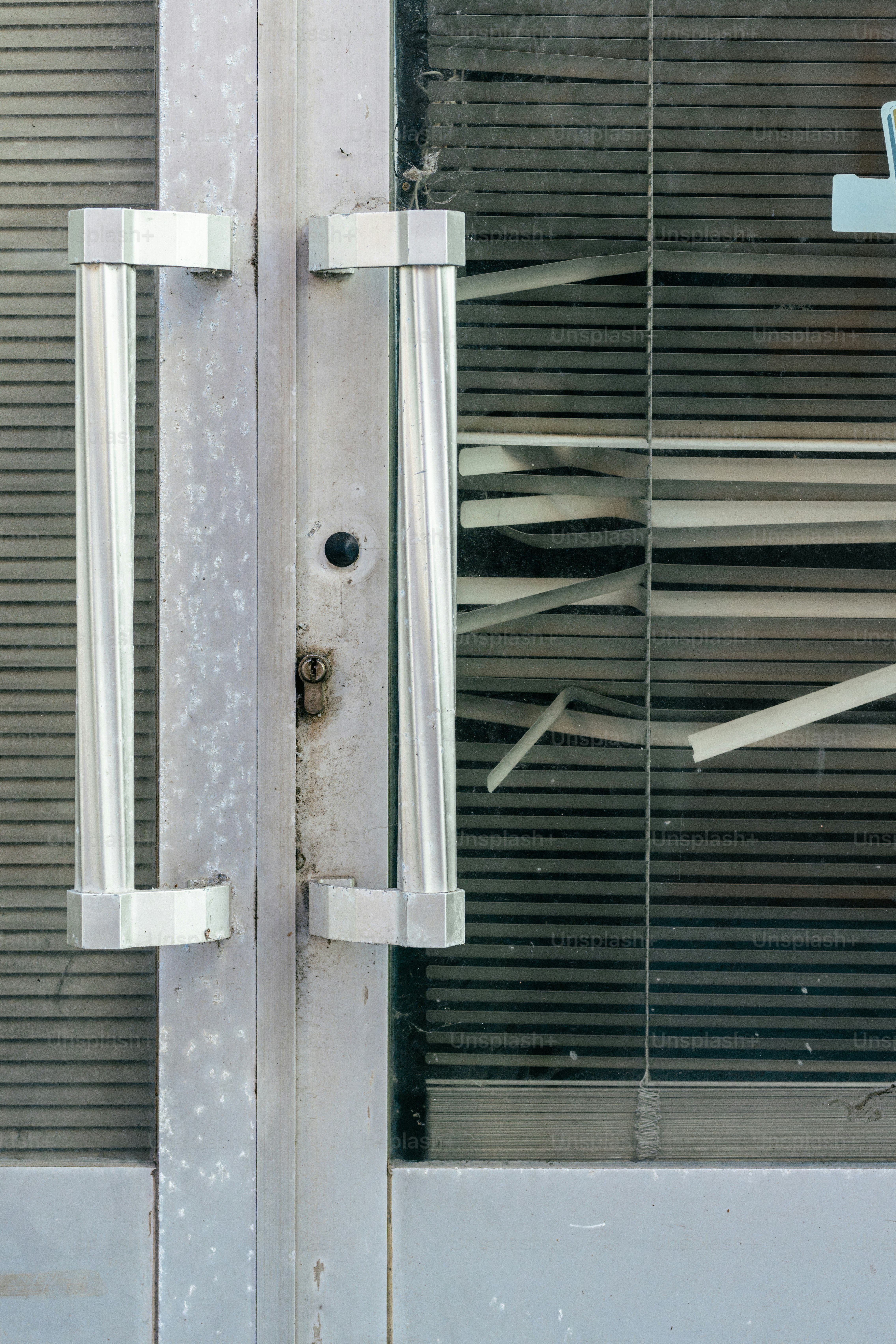 A broken glass door with a broken handle