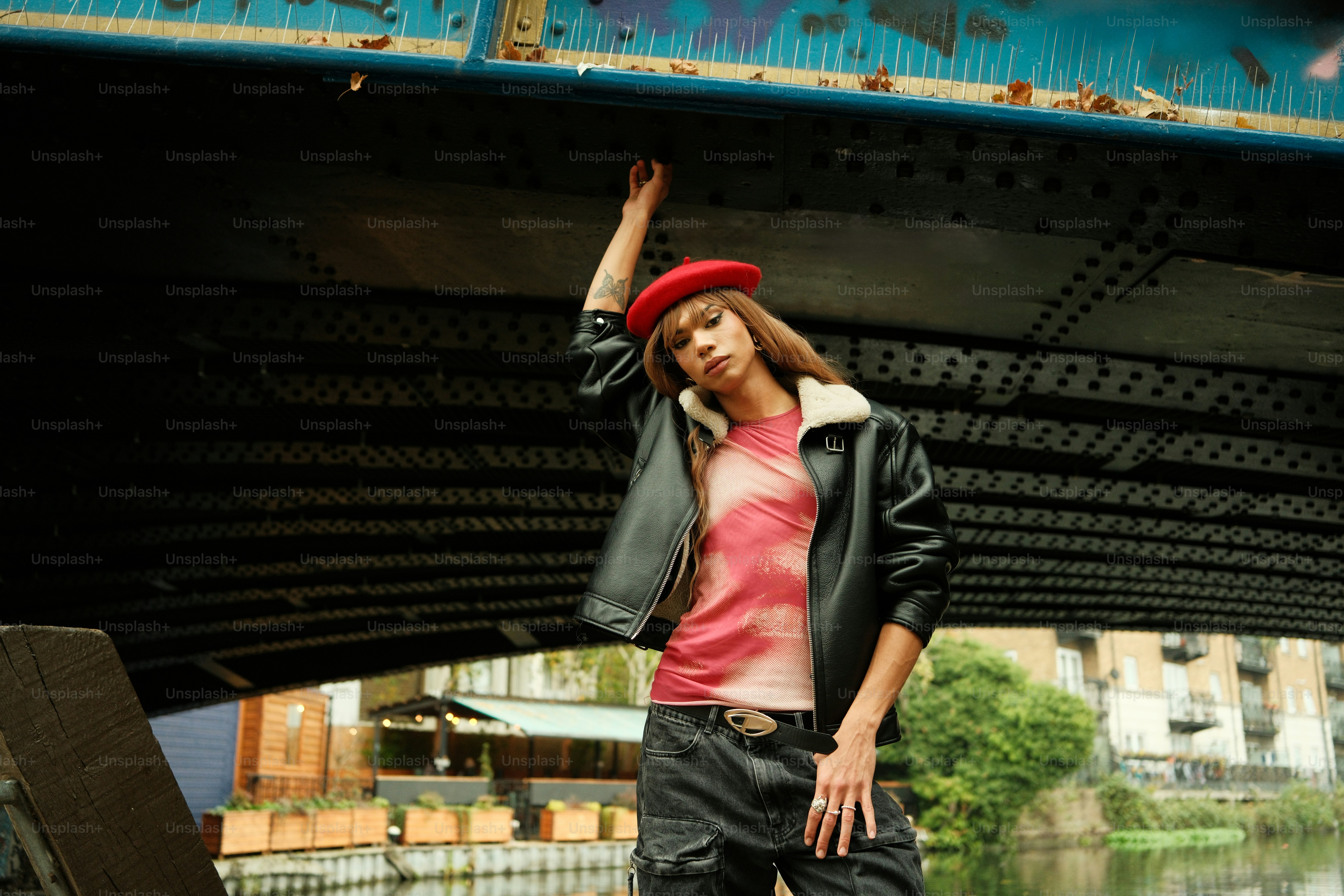A woman standing on a skateboard under a bridge