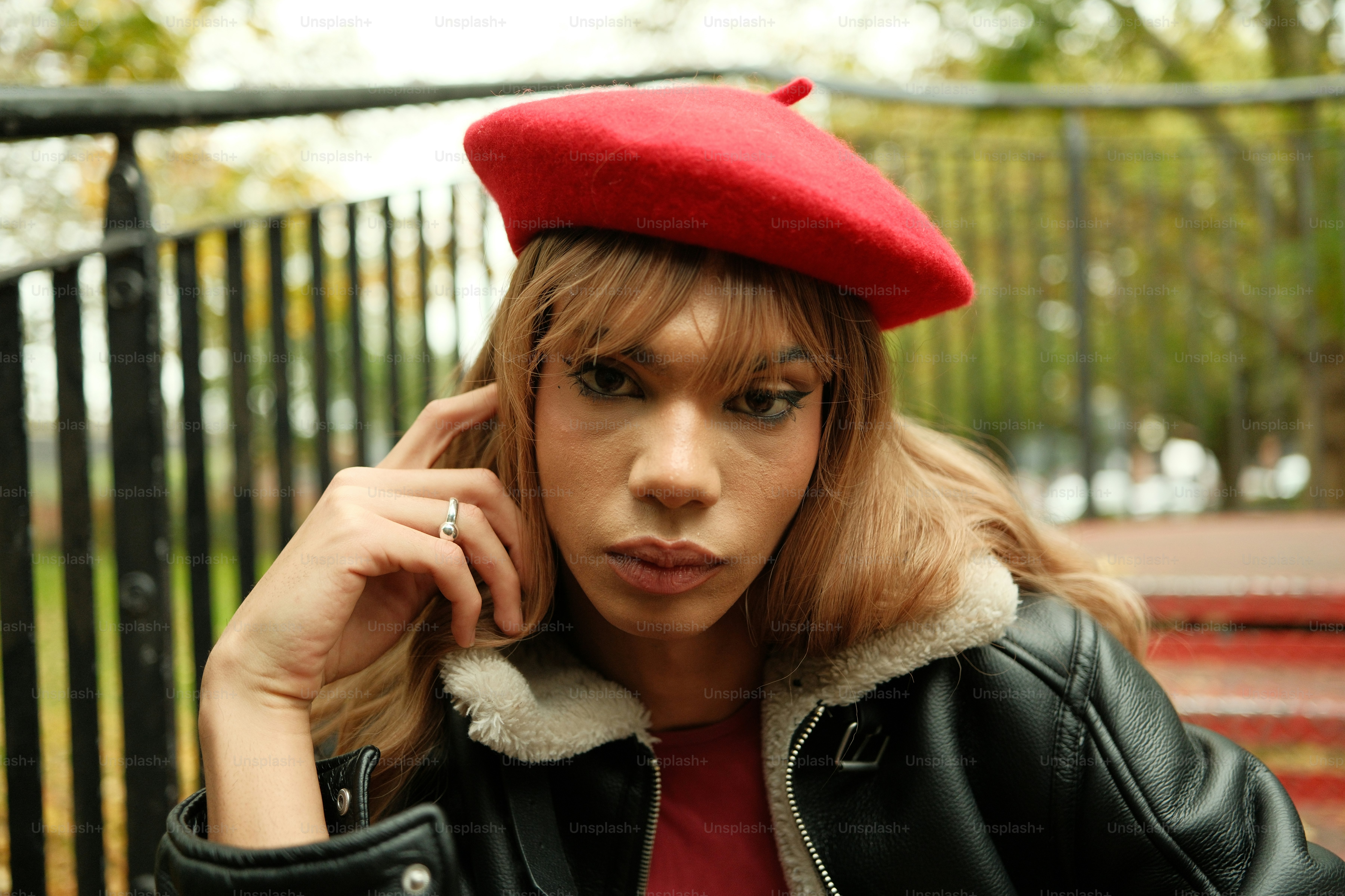 A woman in a red hat is sitting on a bench