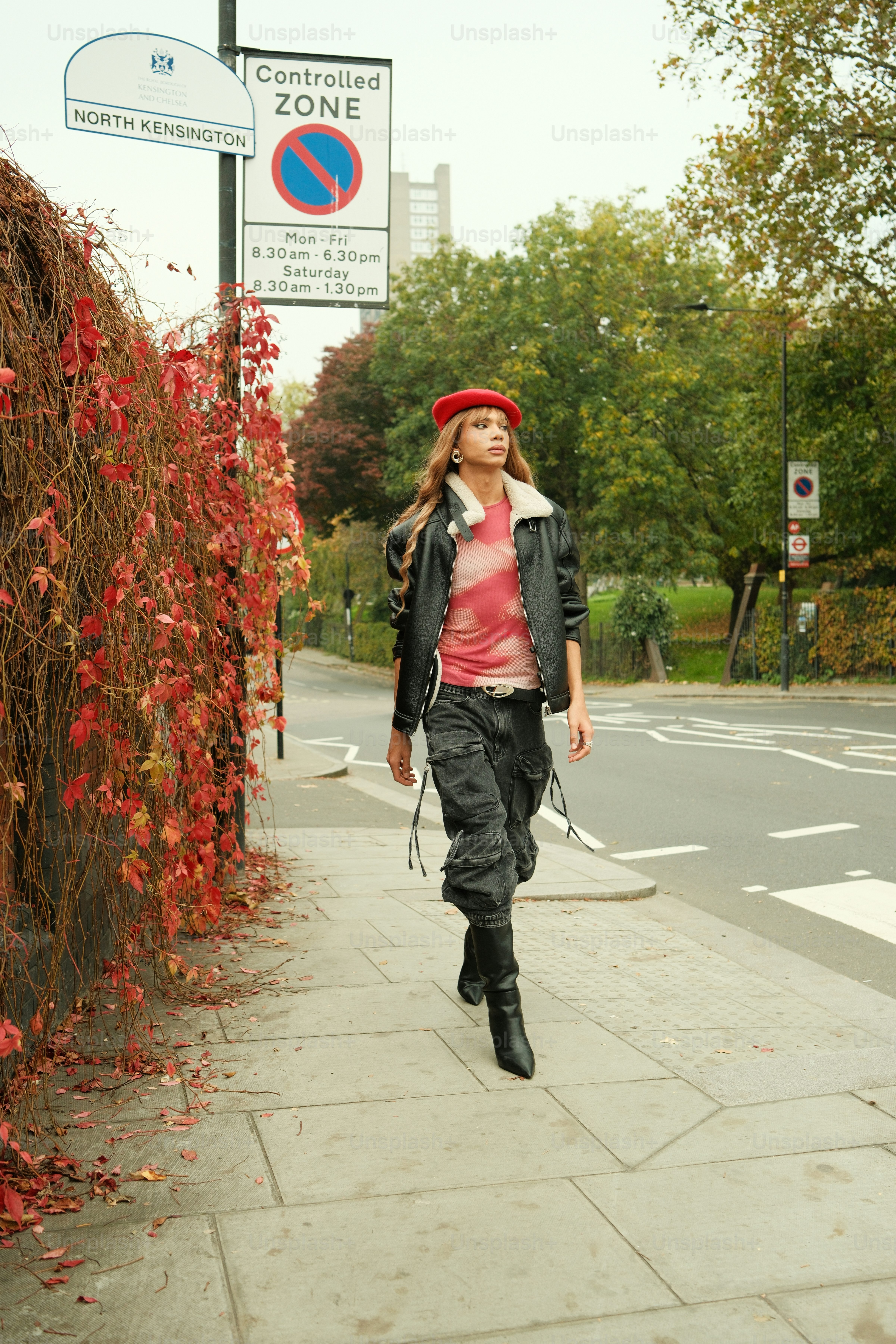 덤불 옆 보도를 걷고 있는 여성