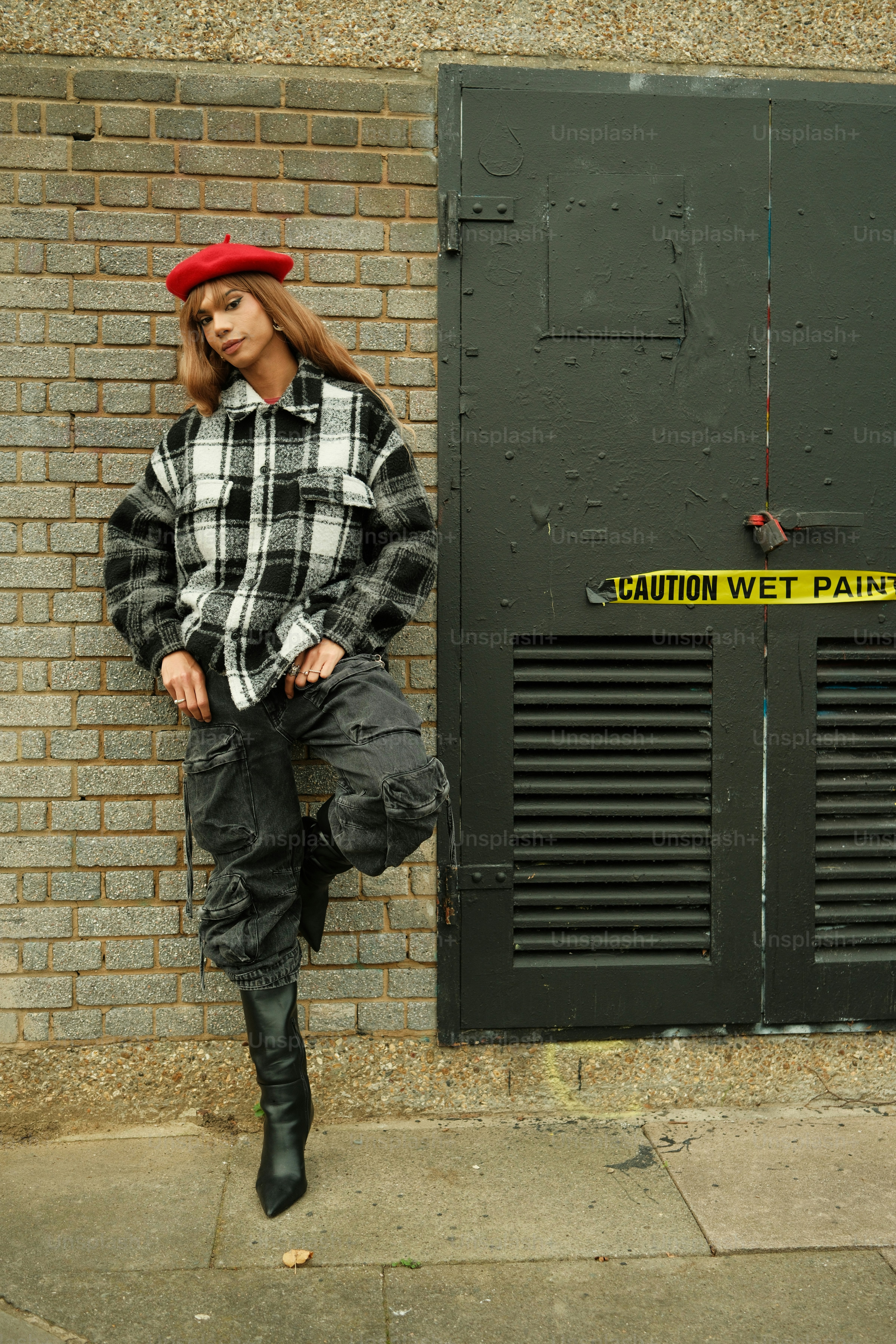 A woman standing in front of a brick wall