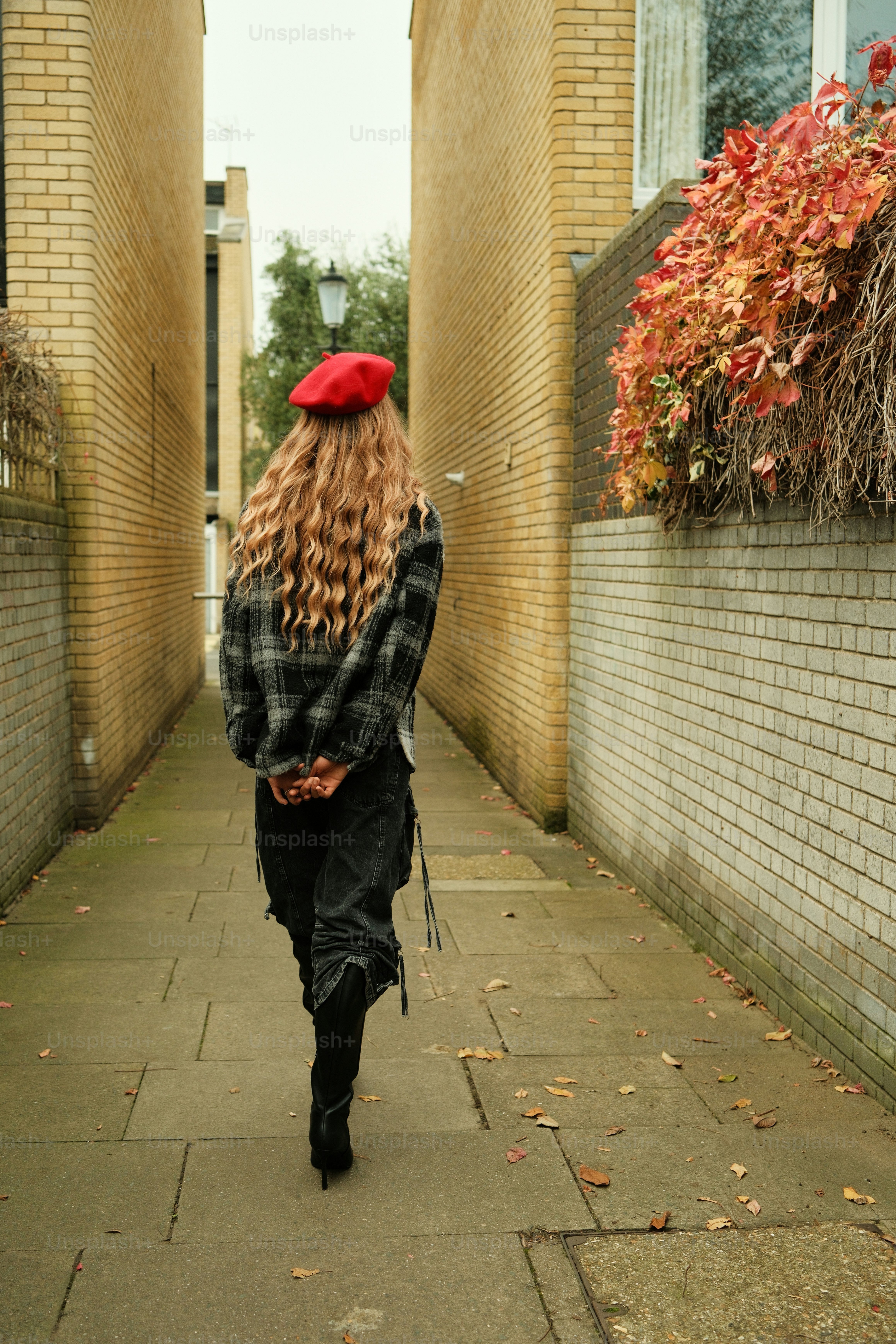 A woman with long hair walking down a sidewalk