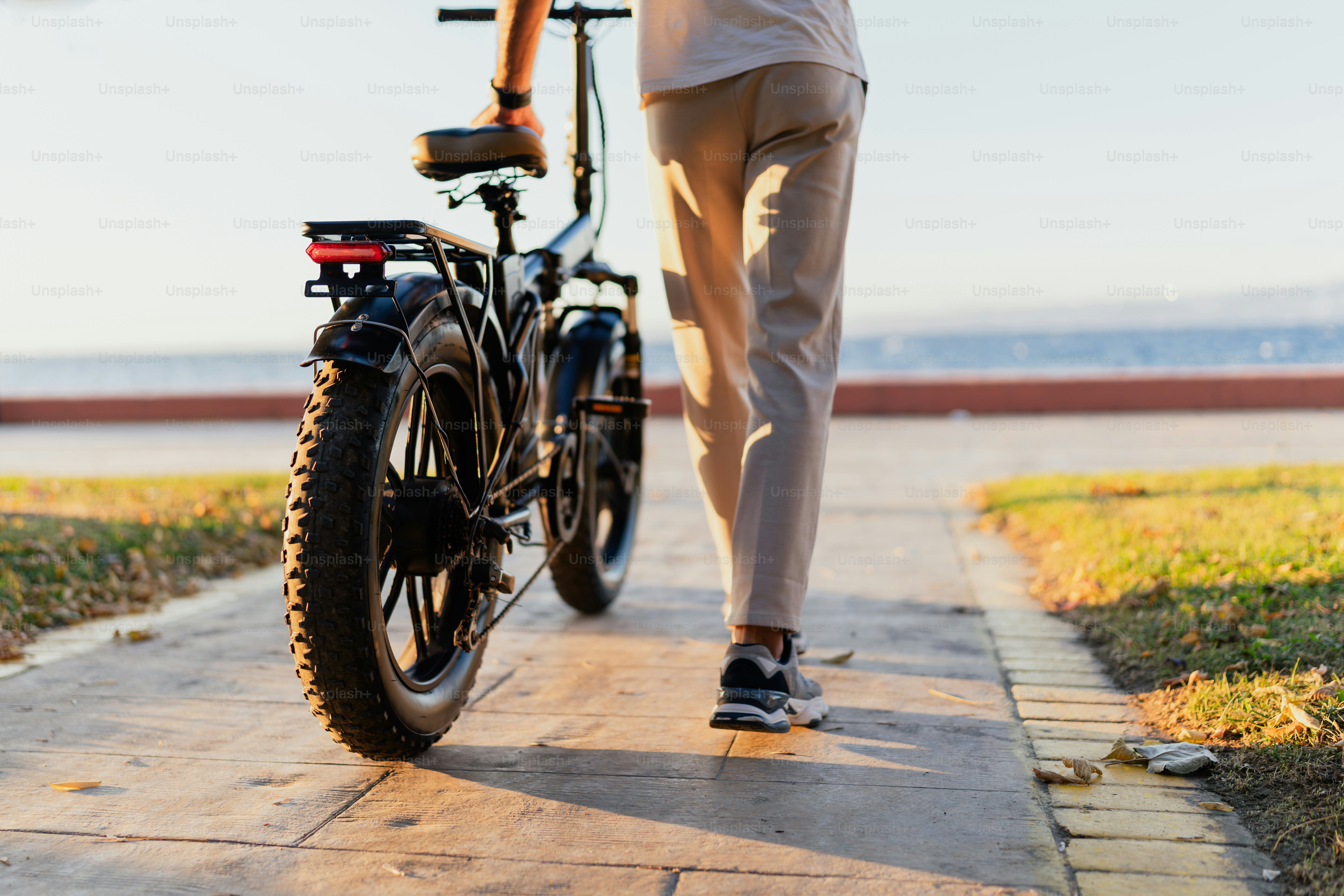 A man standing next to a bike on a sidewalk