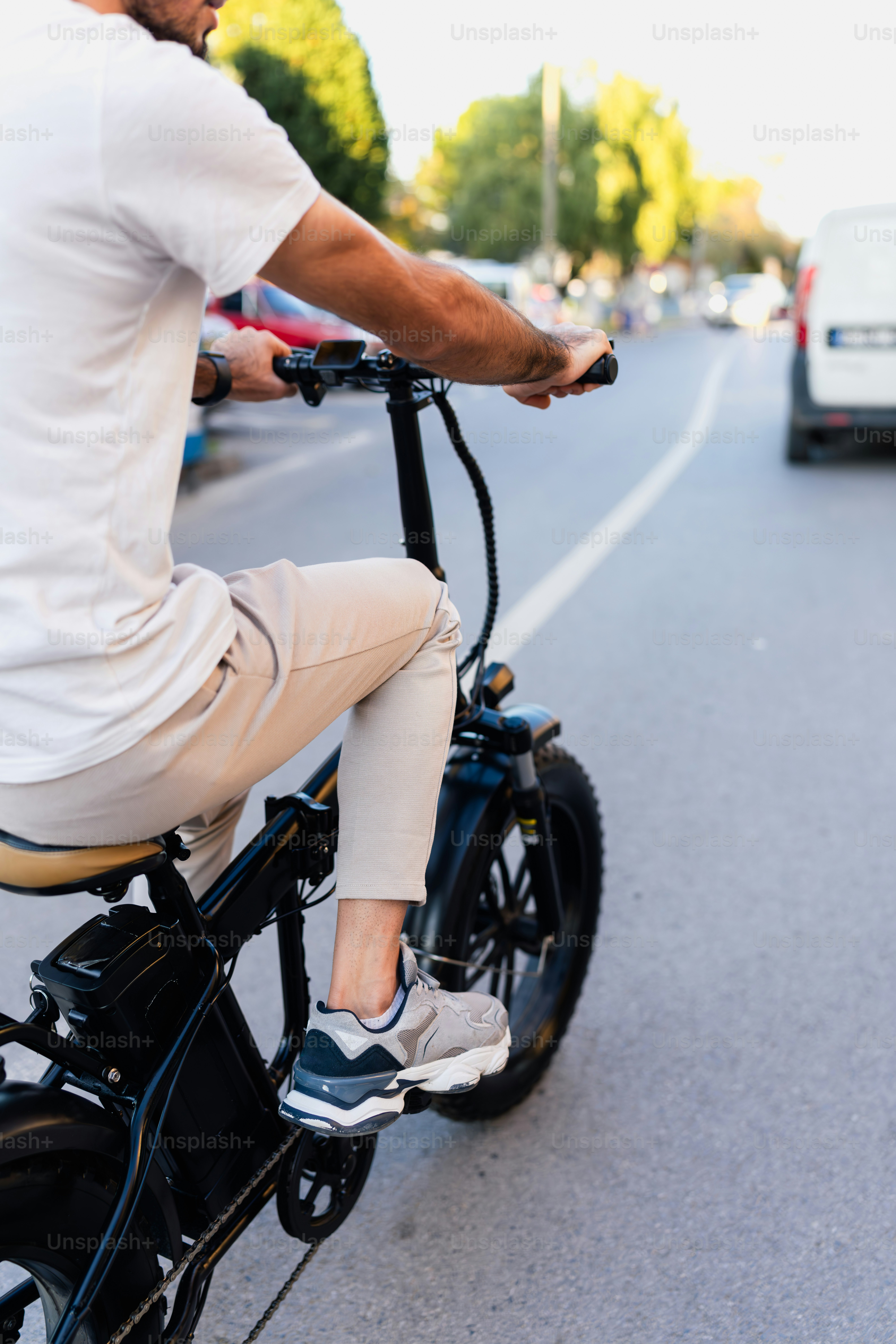 A man riding on the back of a bike down a street