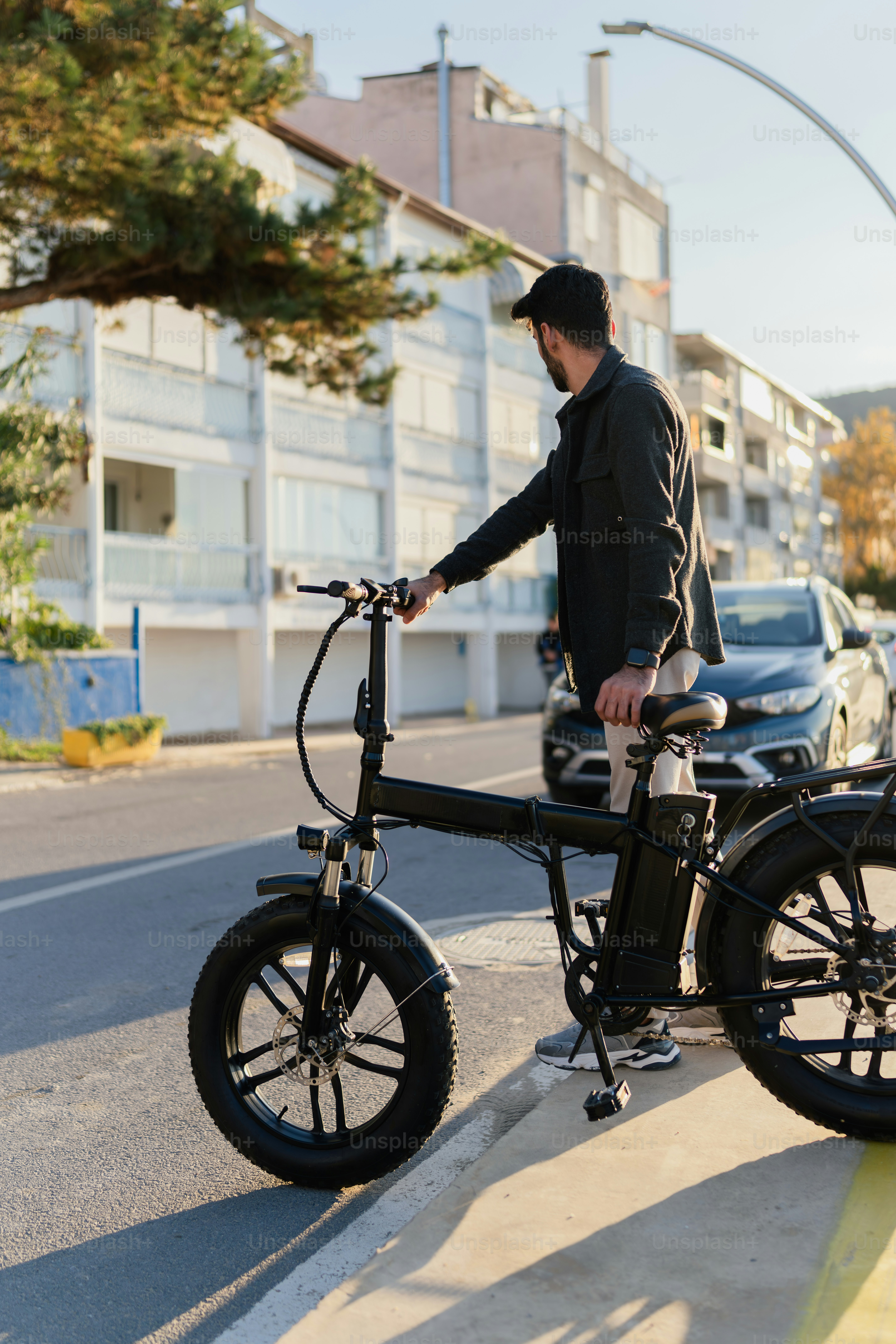 A man standing next to a bike on the side of a road