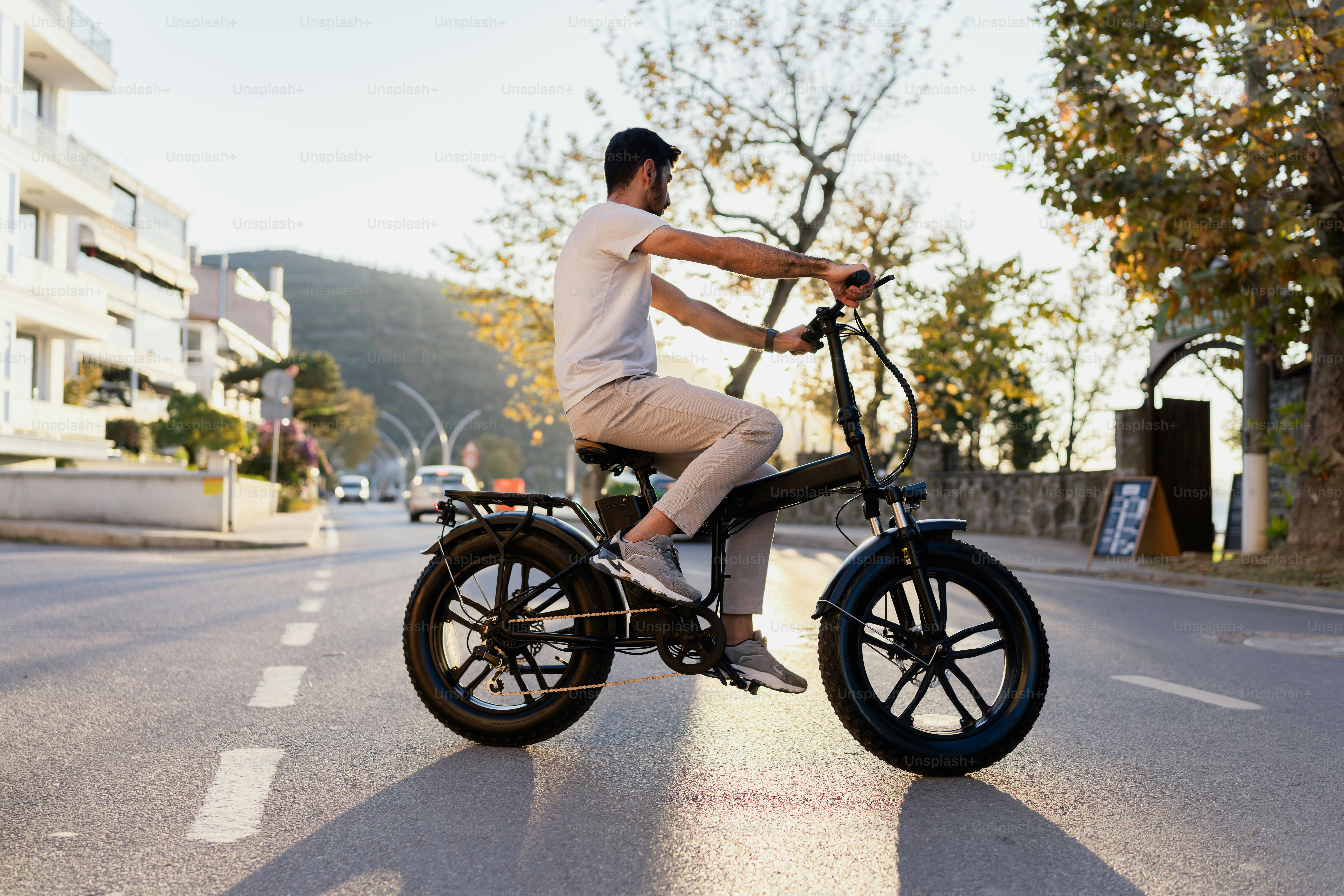 A man riding an electric bike down a street