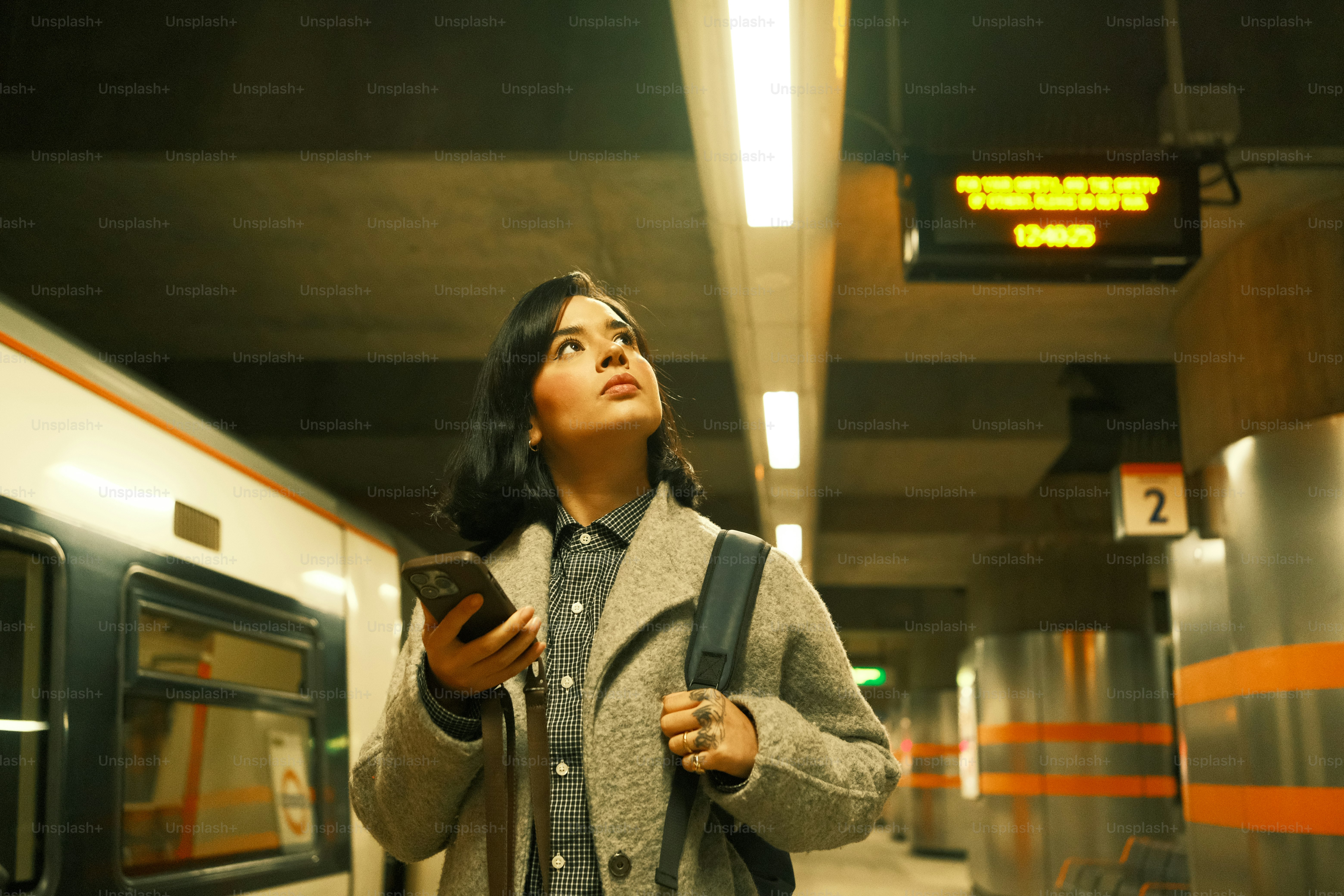A woman standing in a subway station looking up