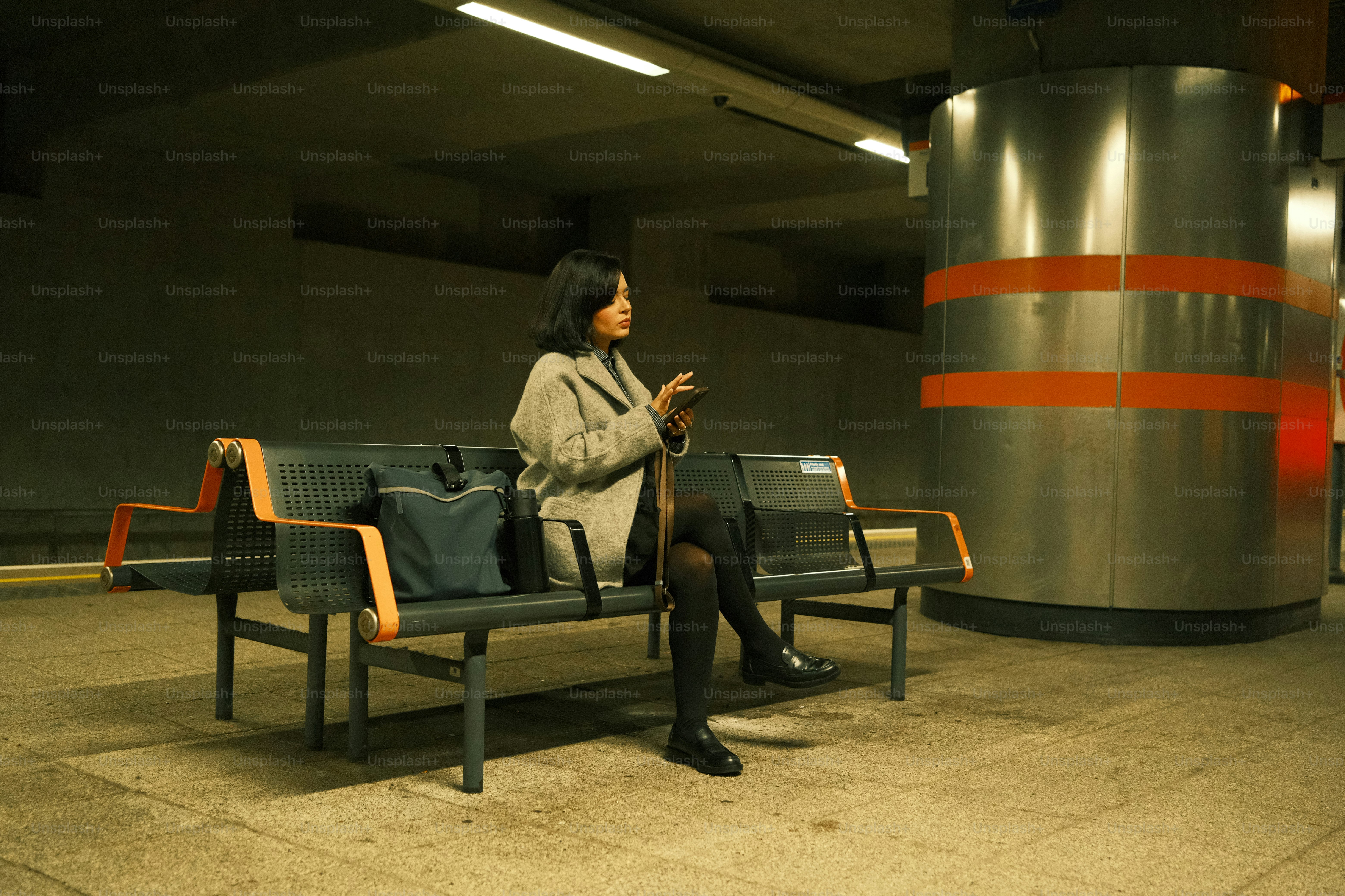 A woman sitting on a bench using a cell phone