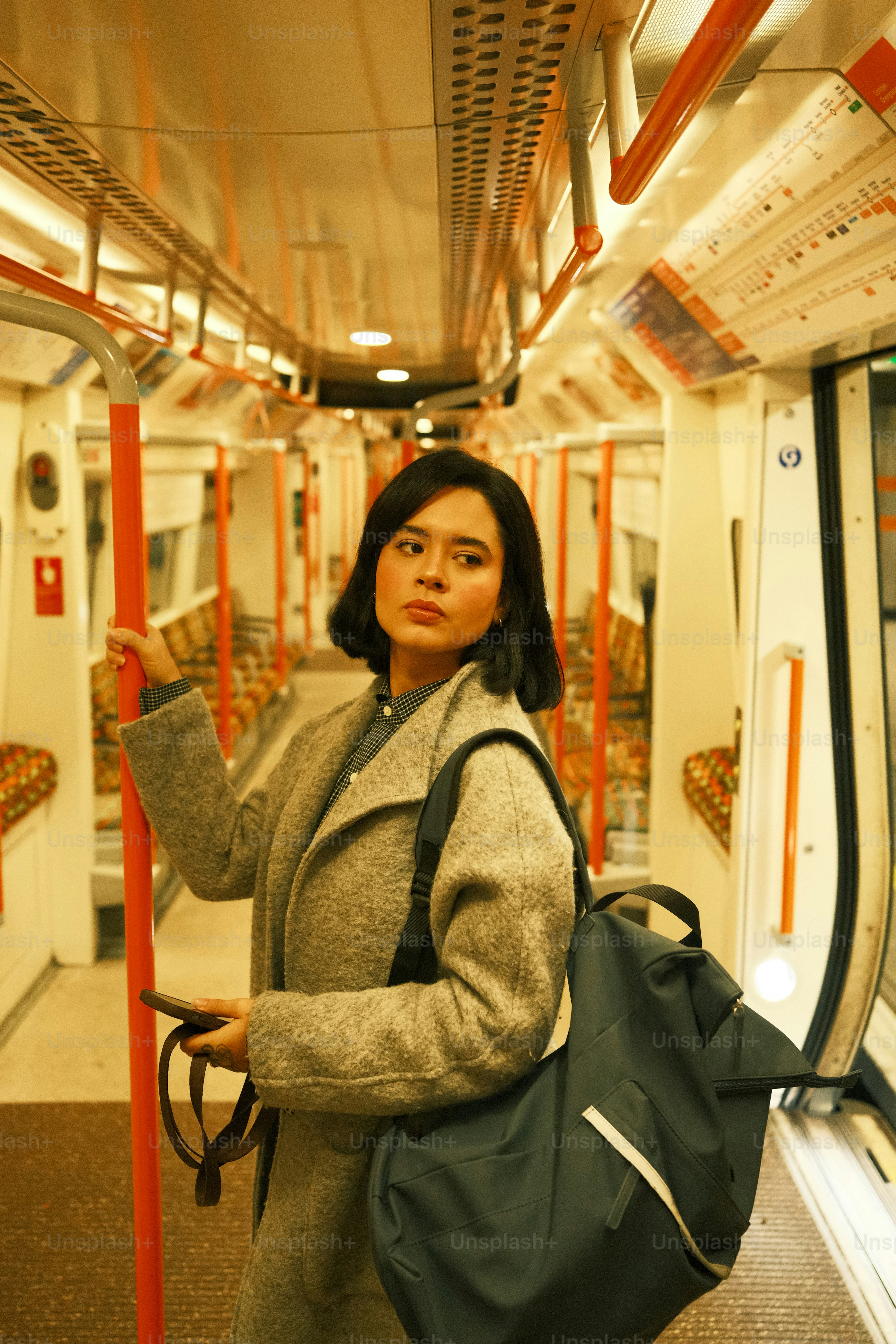 A woman standing on a train holding a bag