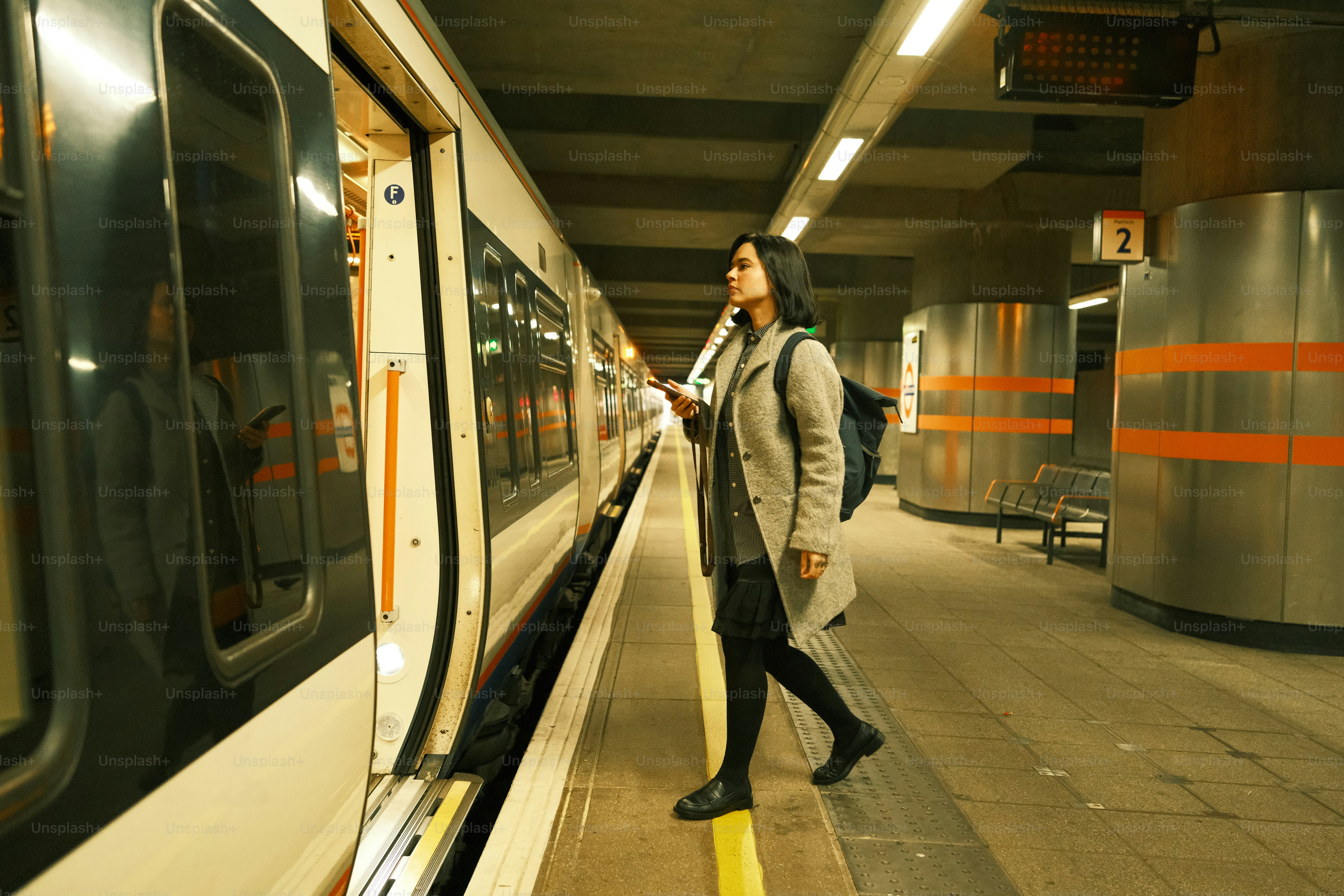 A woman standing on a platform next to a train
