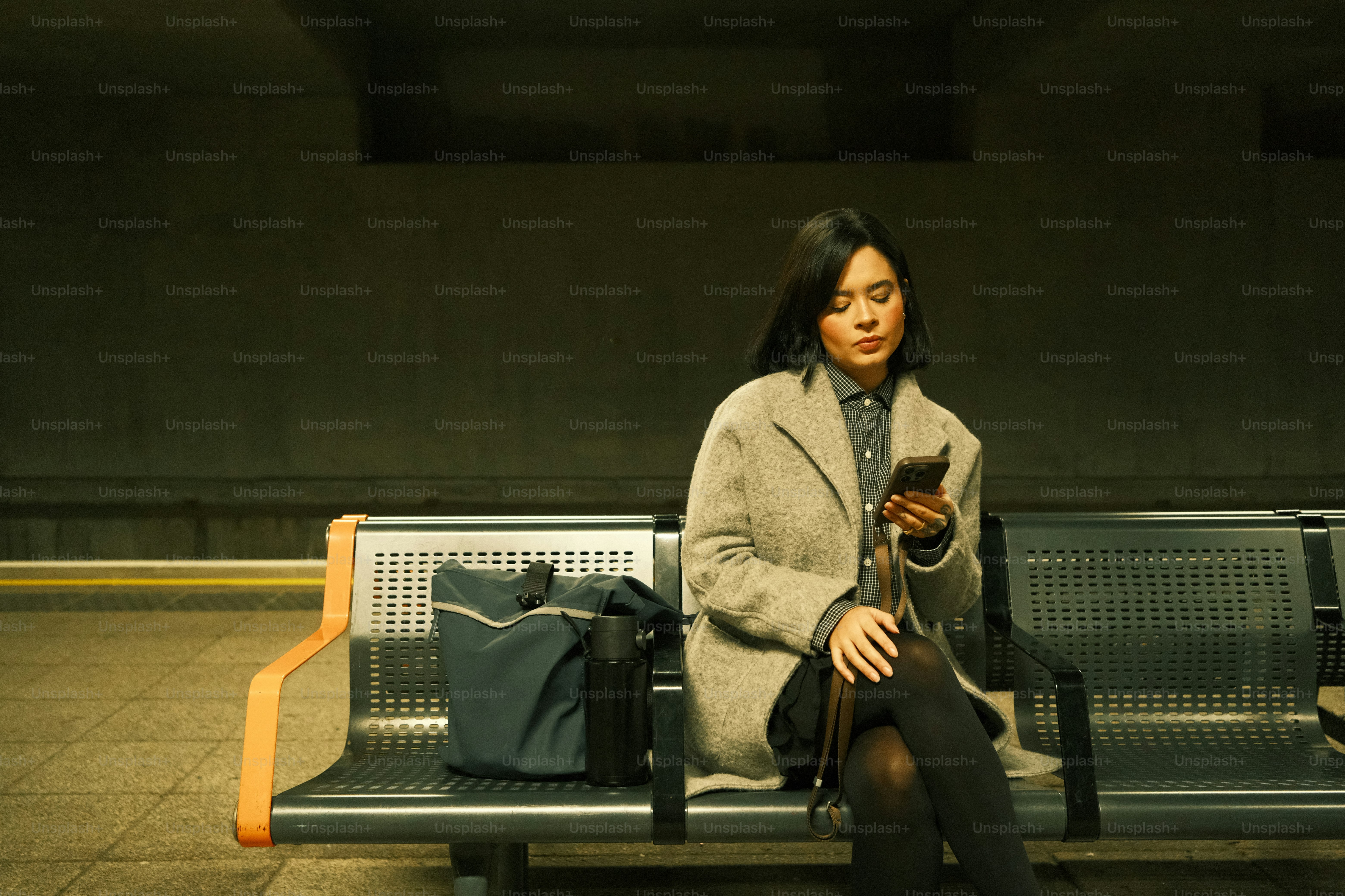 A woman sitting on a bench in a train station