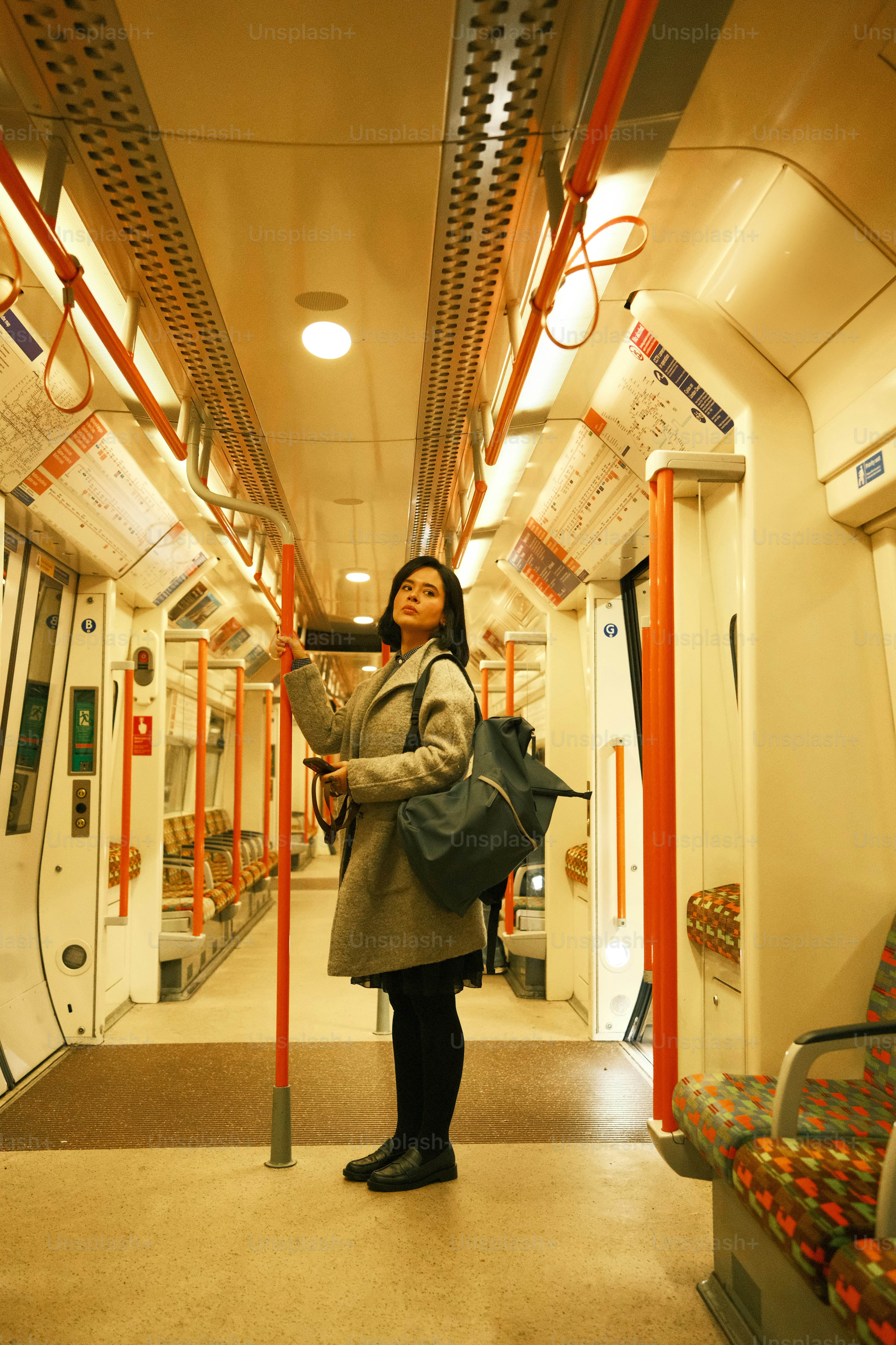 A woman standing on a train with a backpack