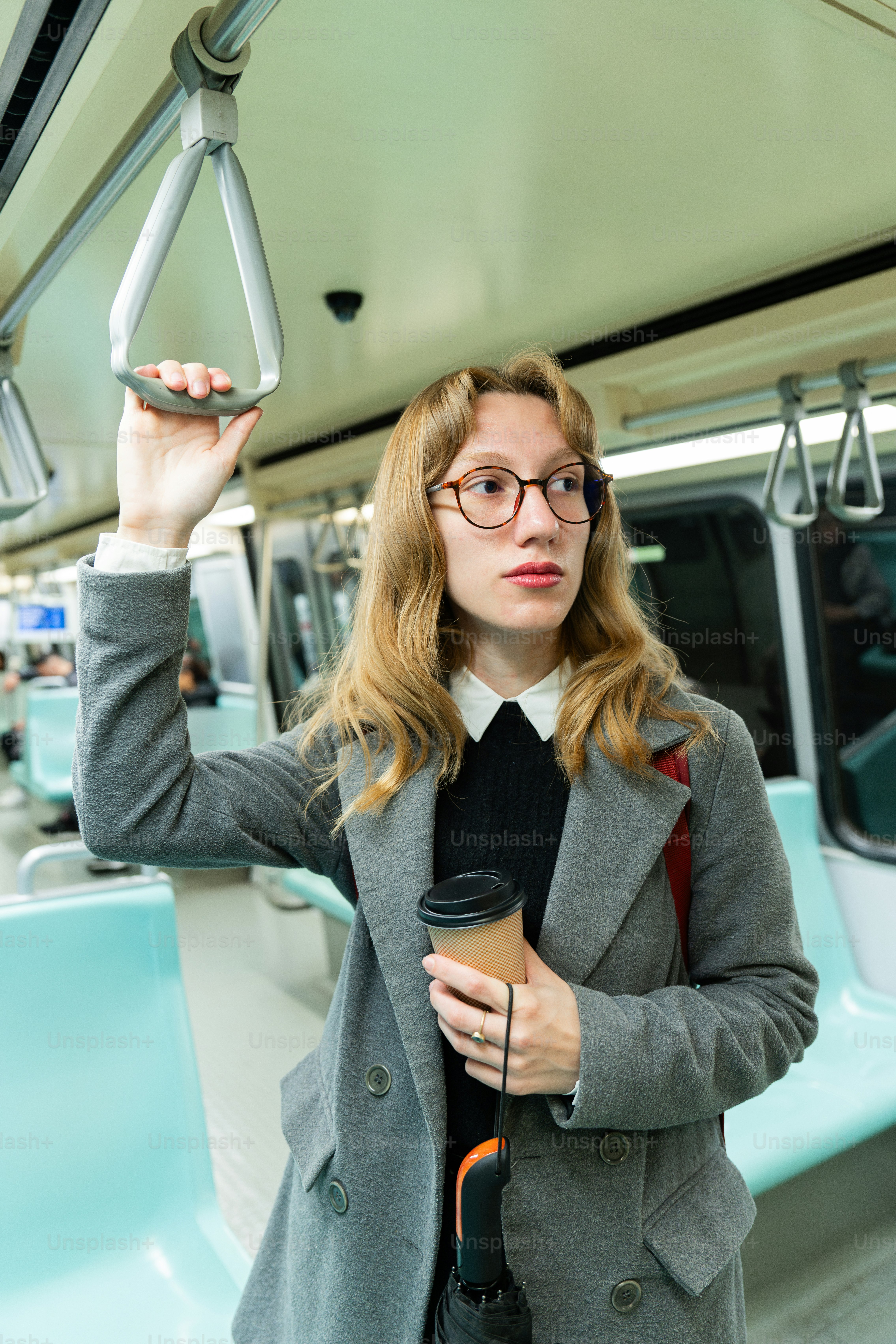 A woman holding a cup of coffee on a bus