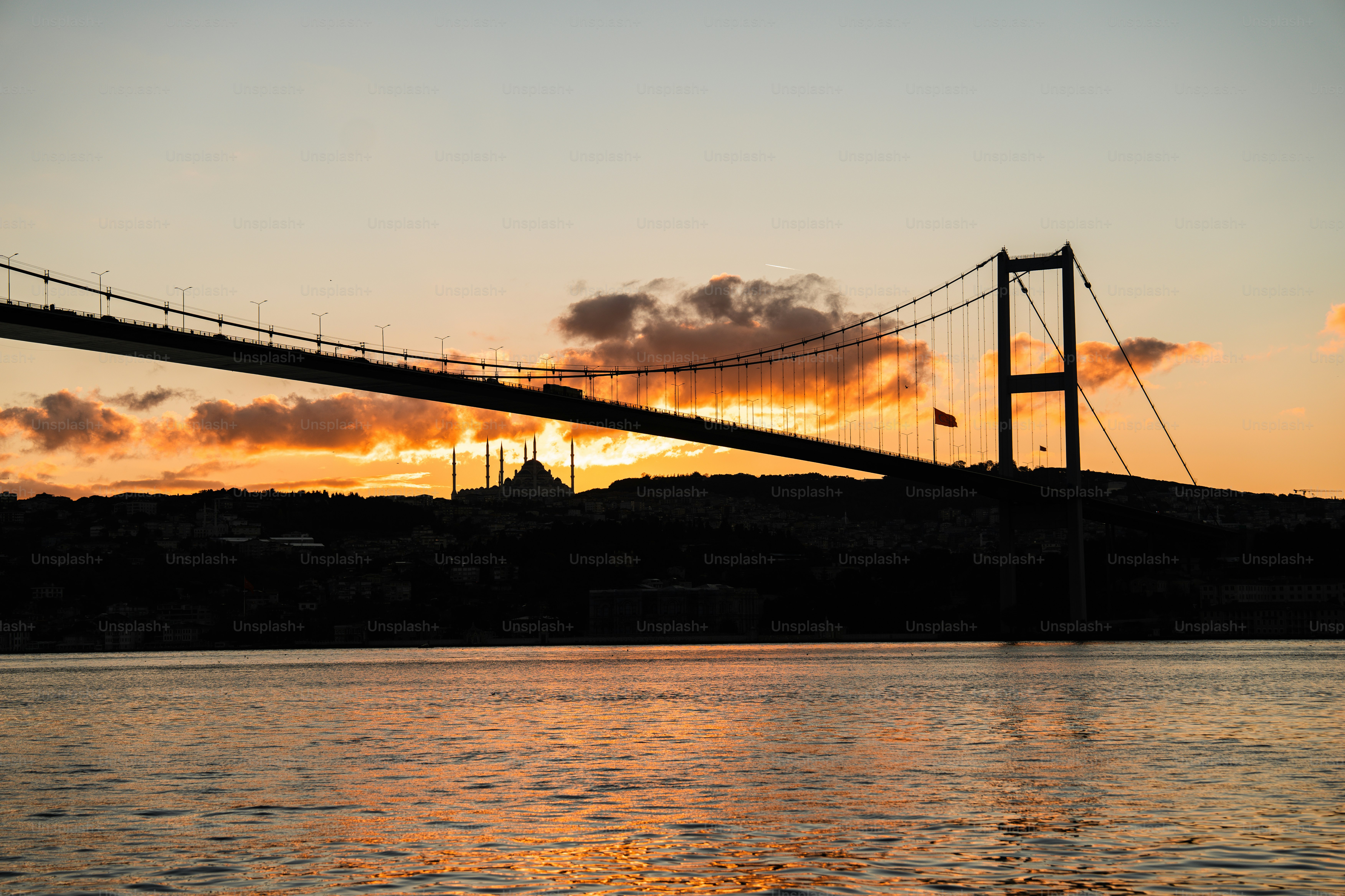 Il sole sta tramontando sull'acqua e su un ponte