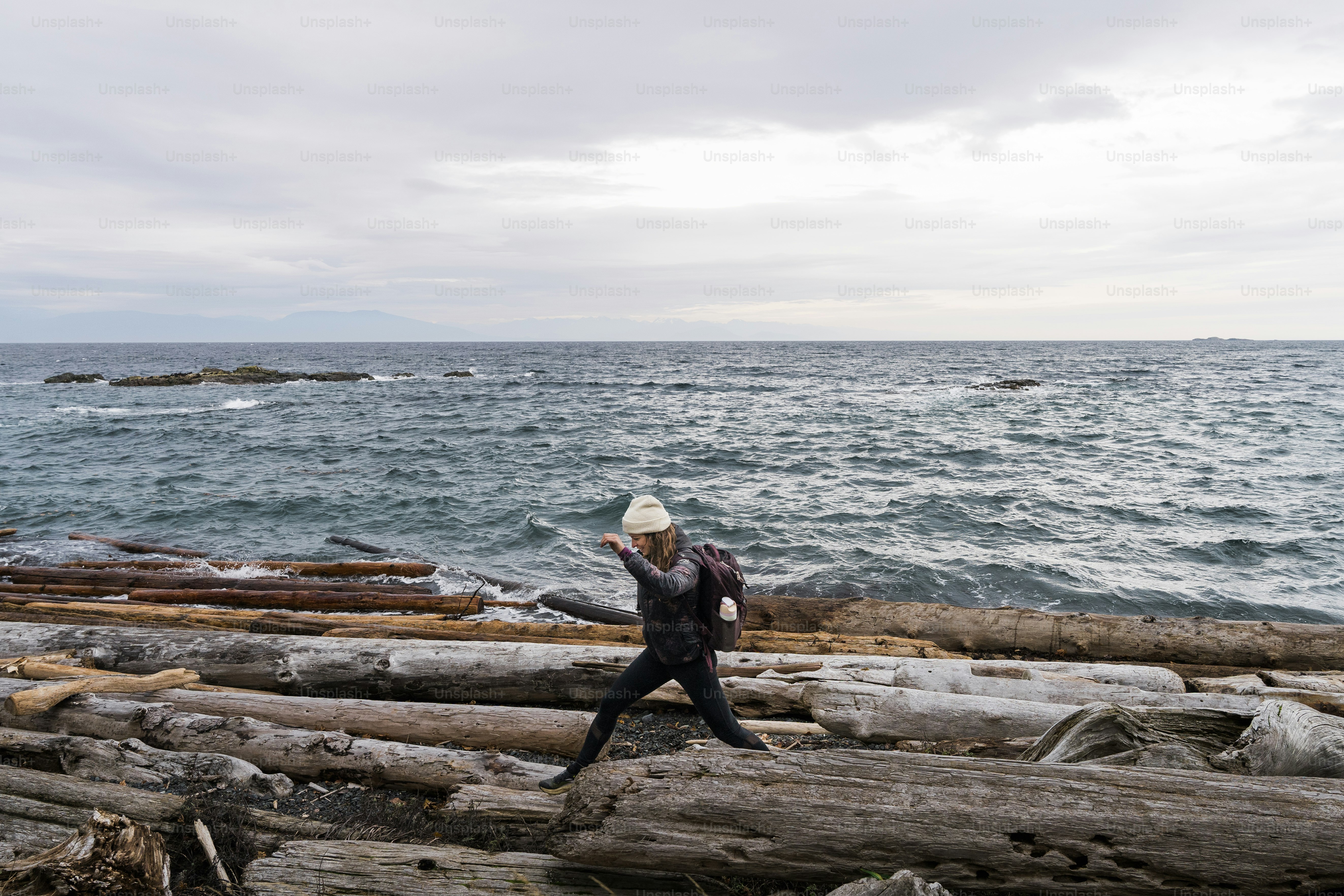 A person walking on a log by the water
