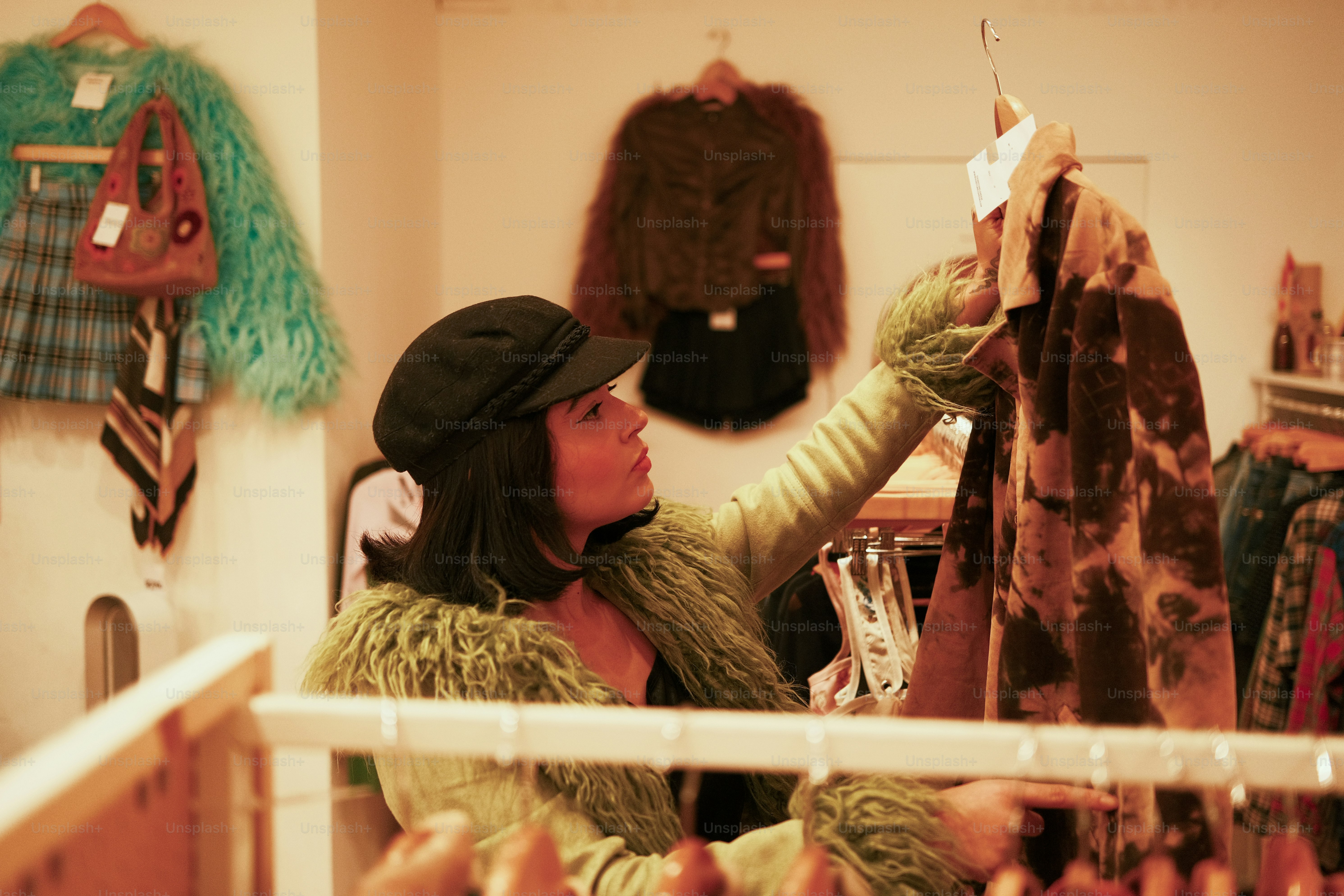 A woman is looking at a horse in a stable