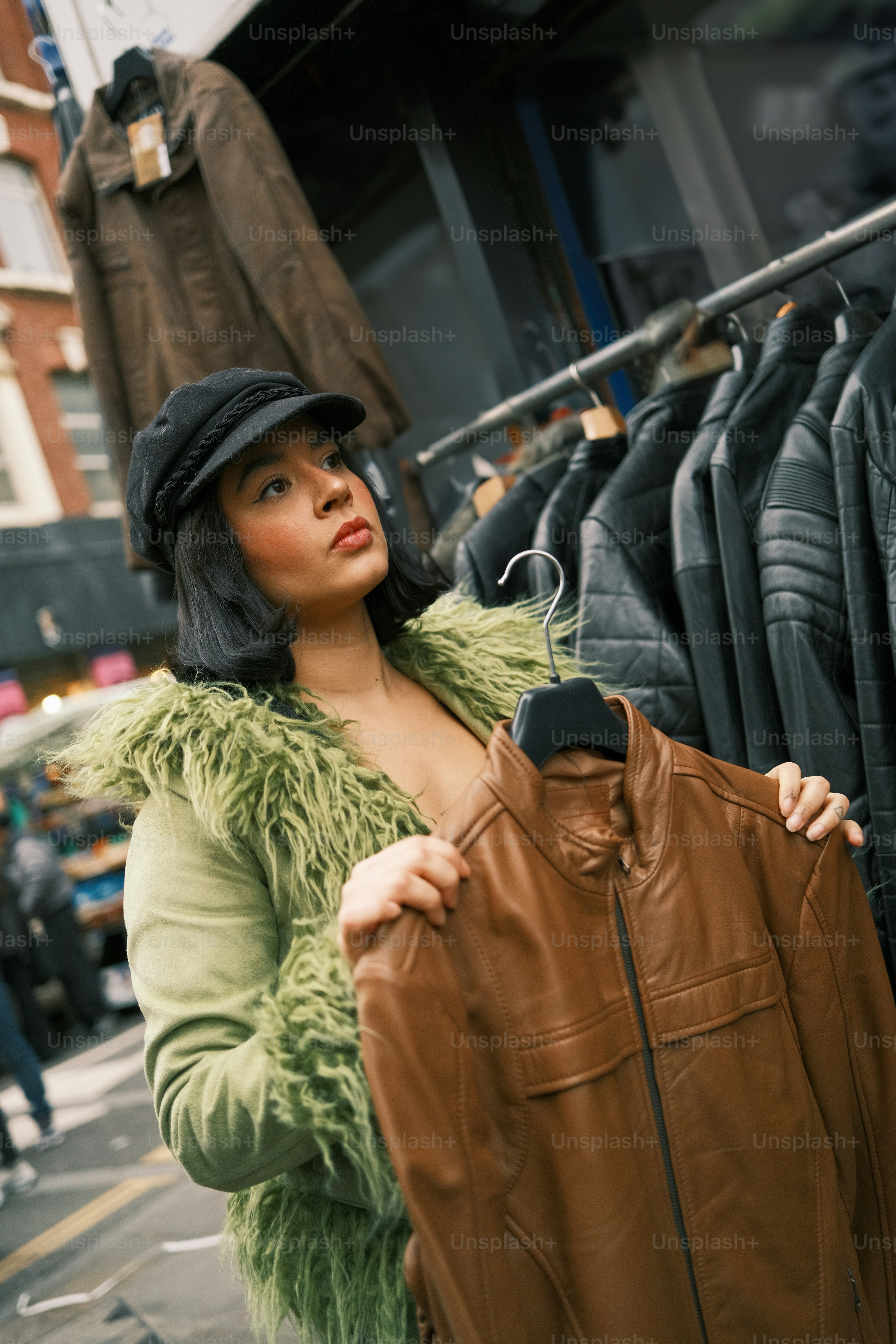 A woman holding a jacket in front of a rack of clothes