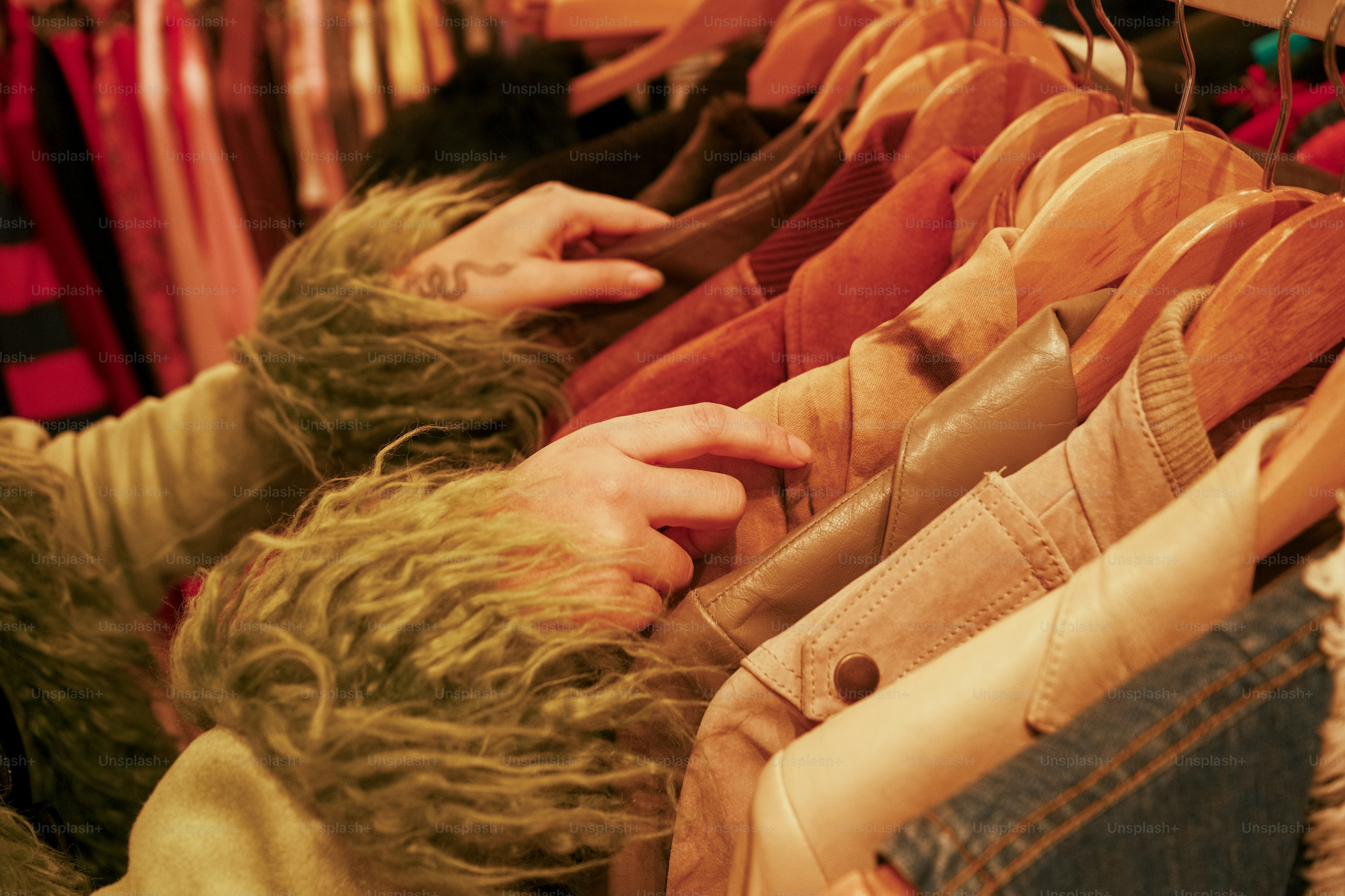 A woman is looking at clothes hanging on a rack