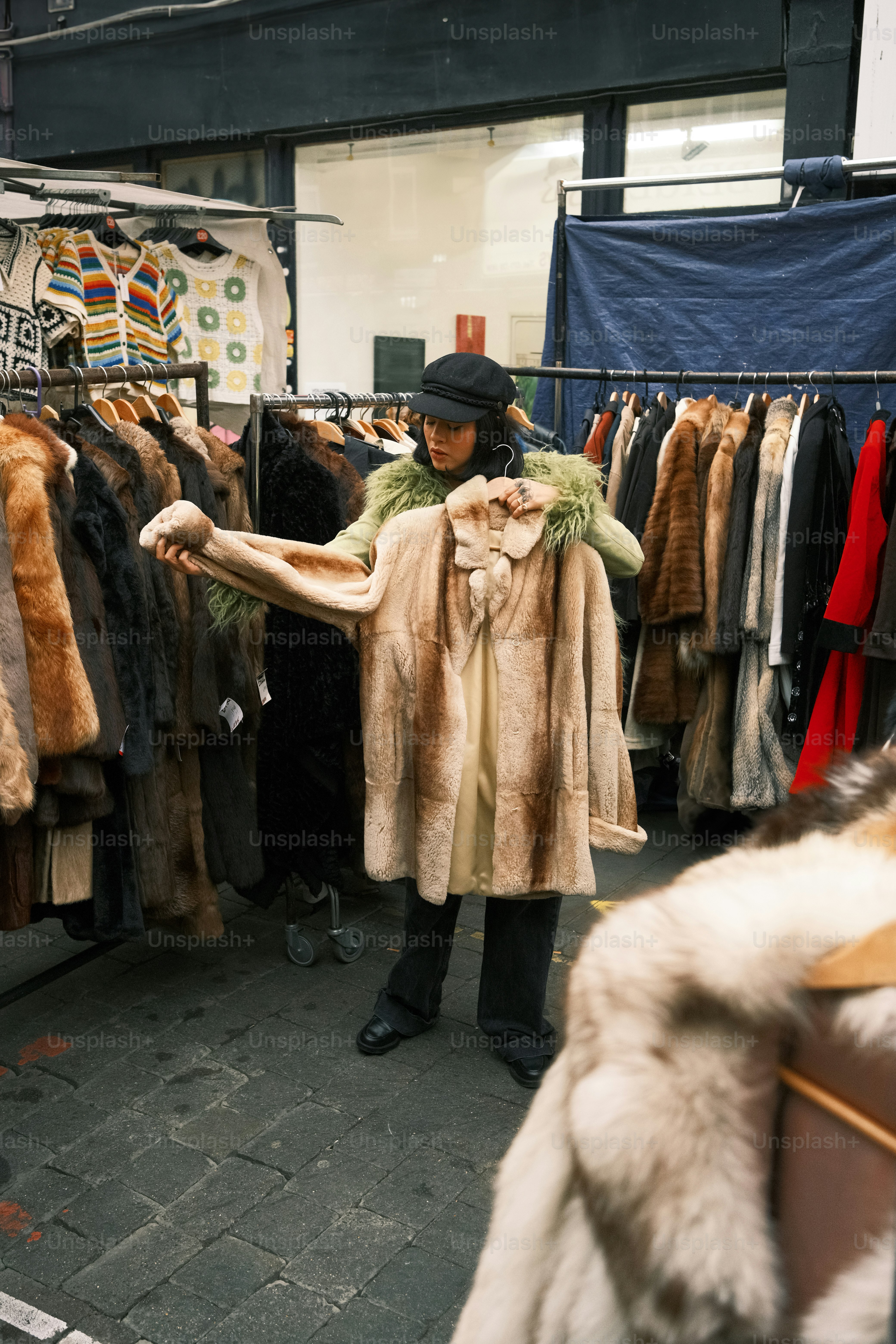 A woman standing in front of a rack of coats
