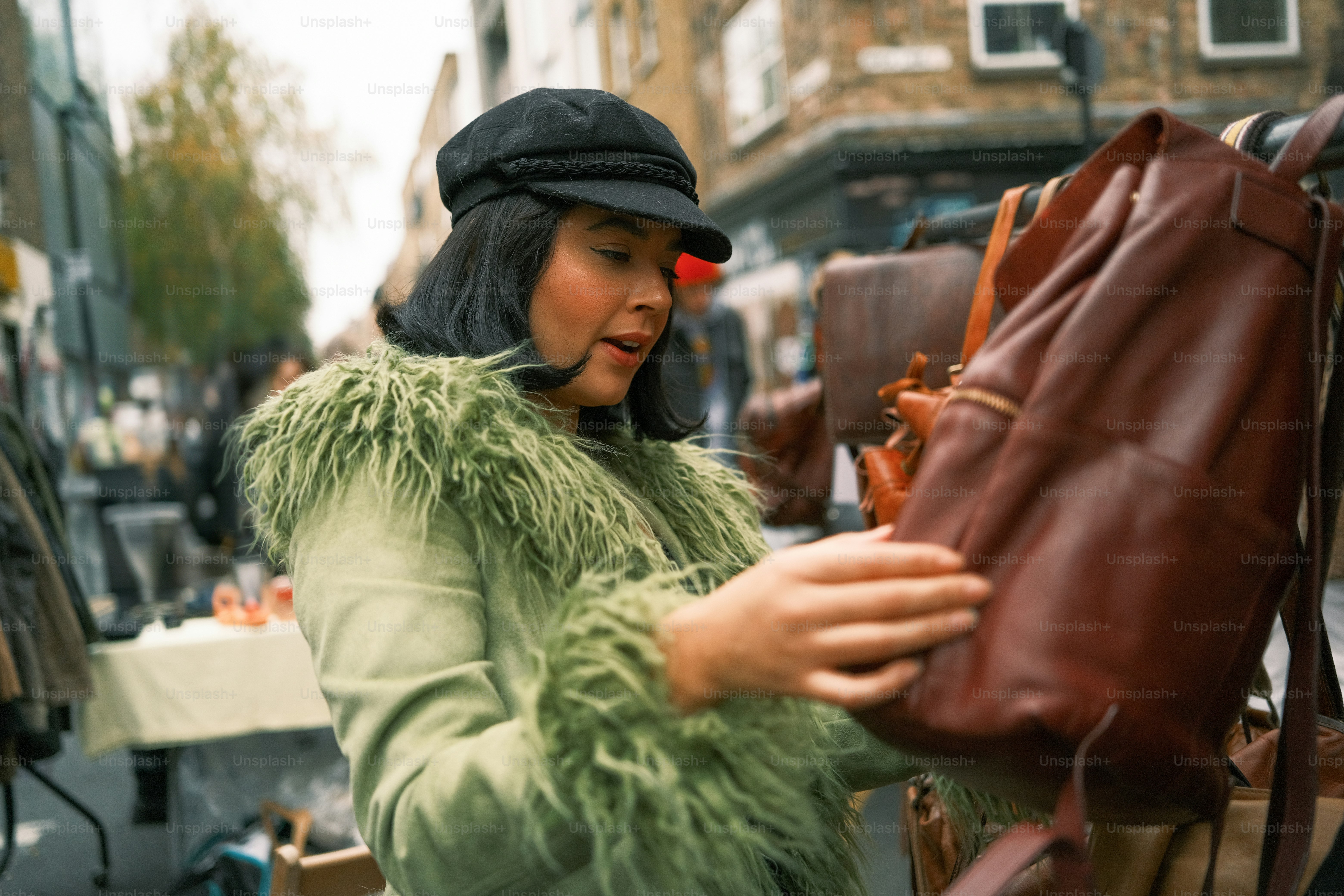 A woman in a fur coat is looking at a purse