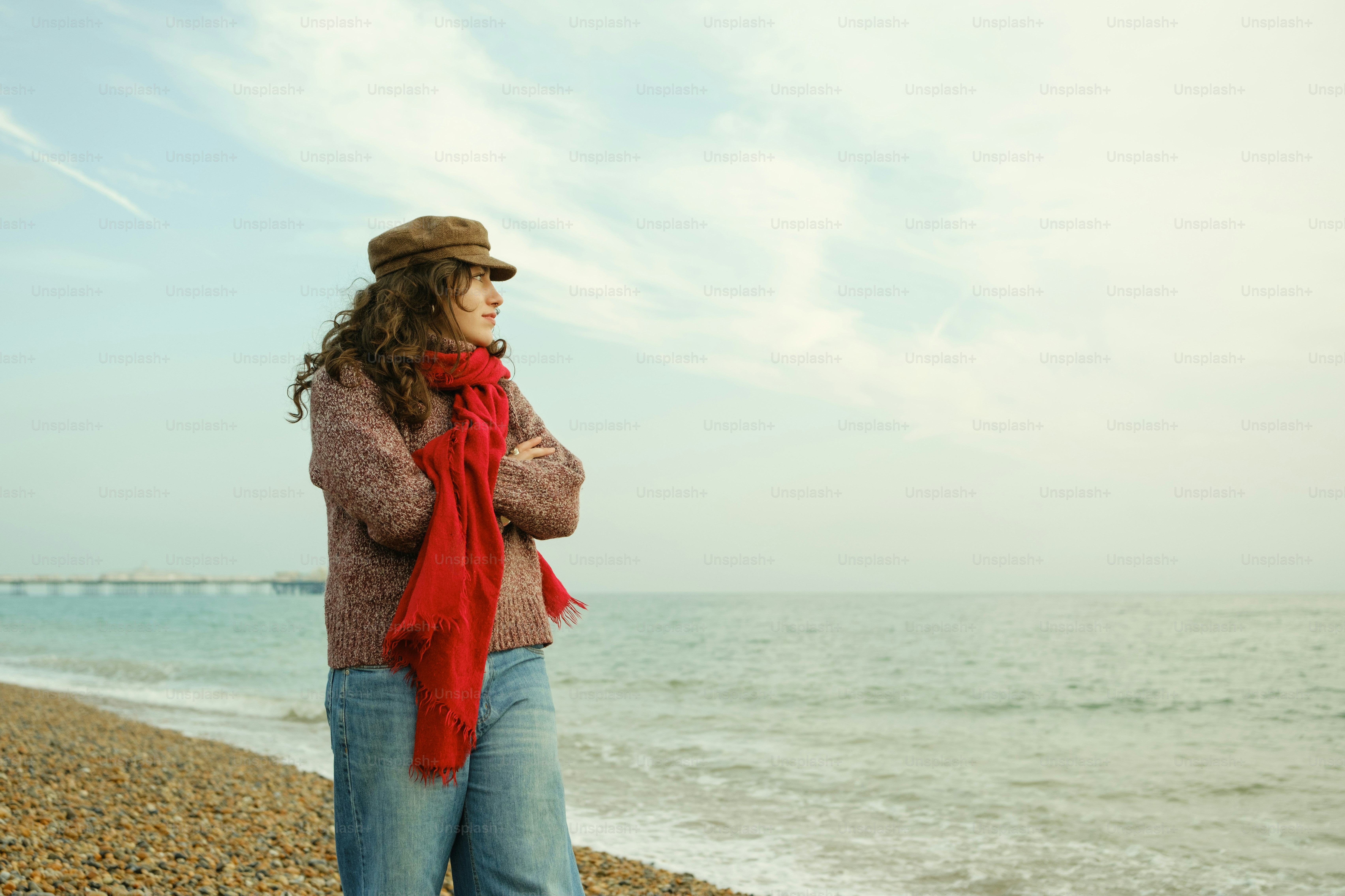 A woman standing on a beach next to the ocean