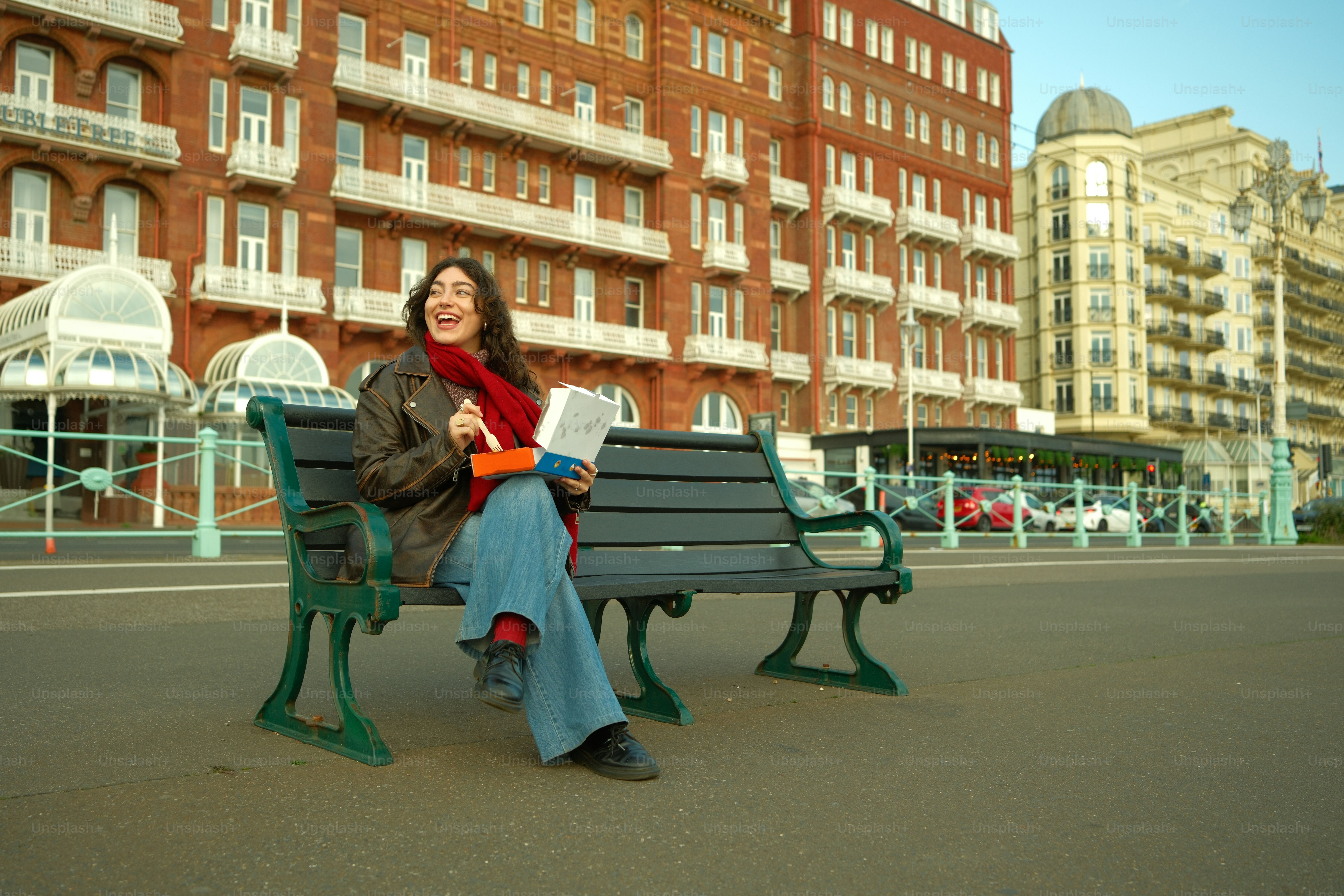 A woman sitting on a bench in front of a building