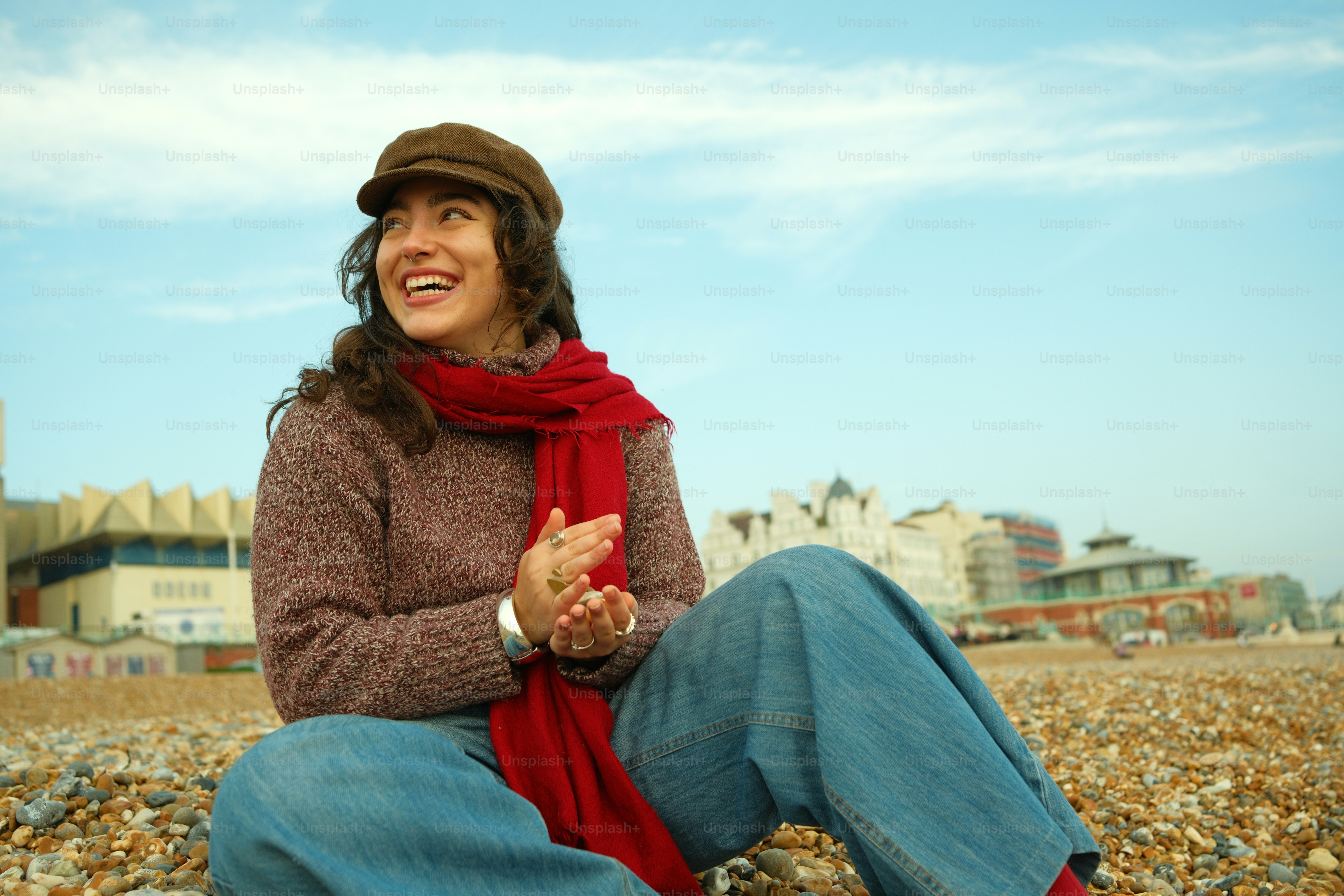 A woman sitting on a rock in front of a building