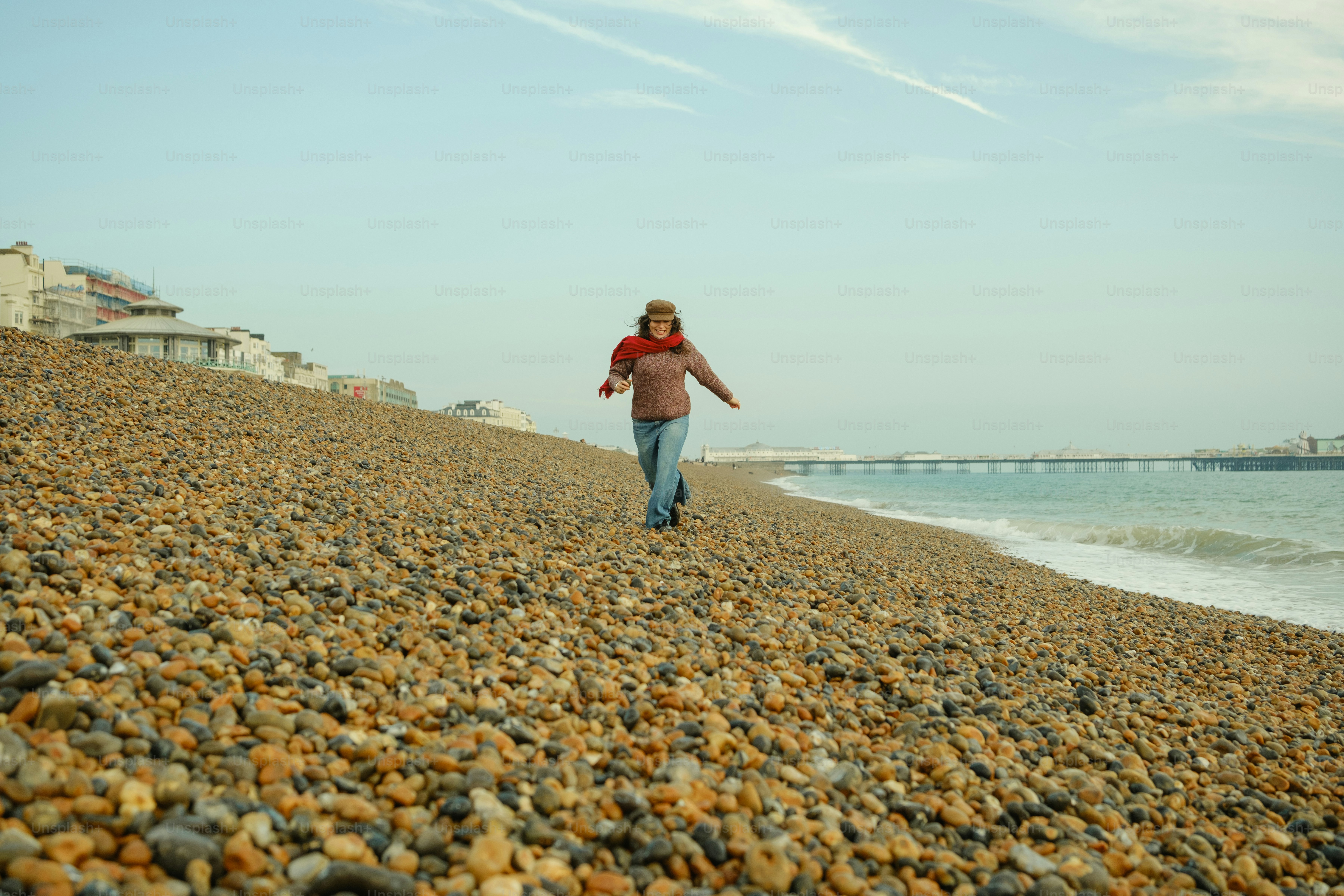 A woman walking along a rocky beach next to the ocean