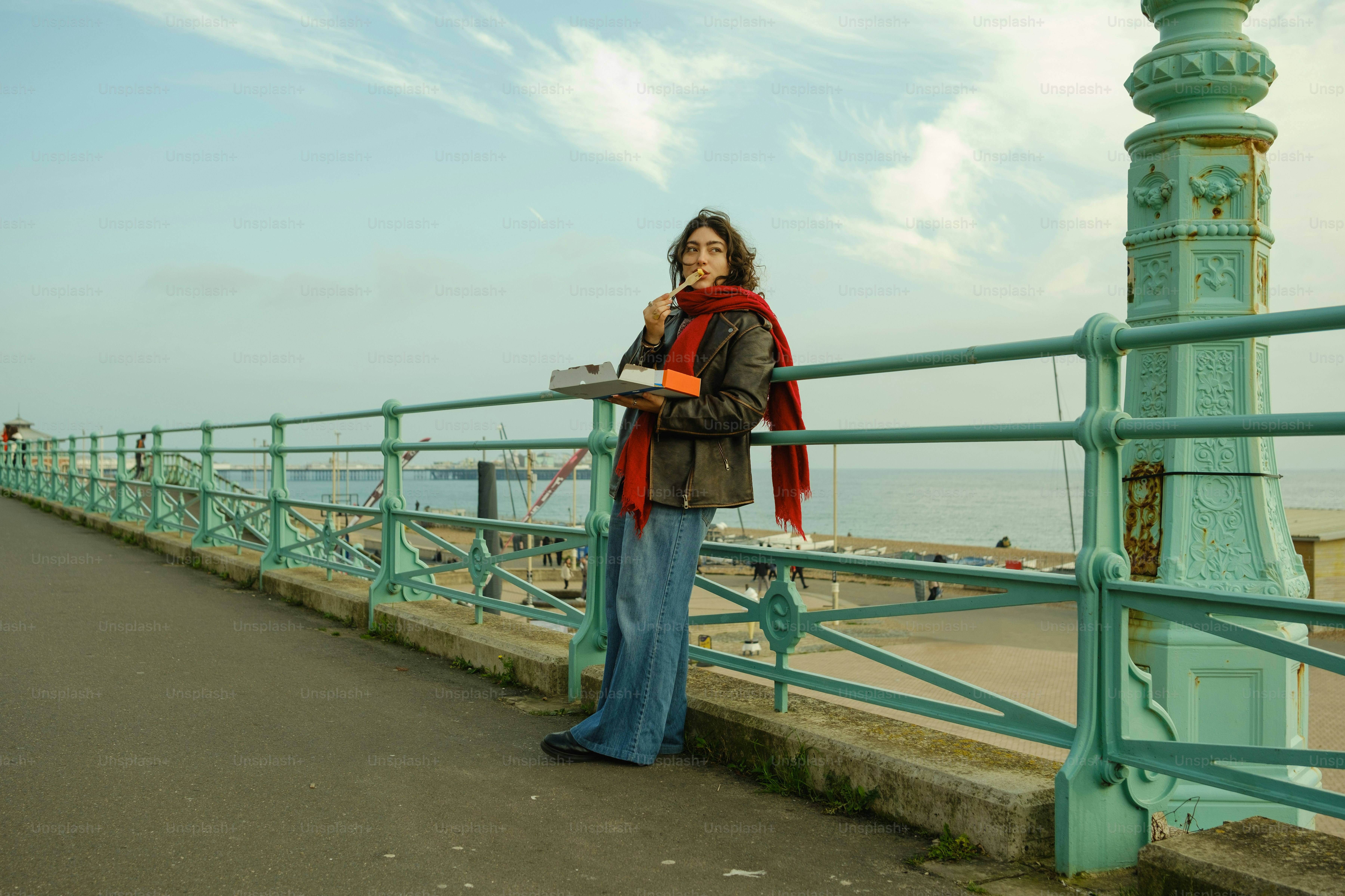 Une femme debout sur un pont à côté de l’océan