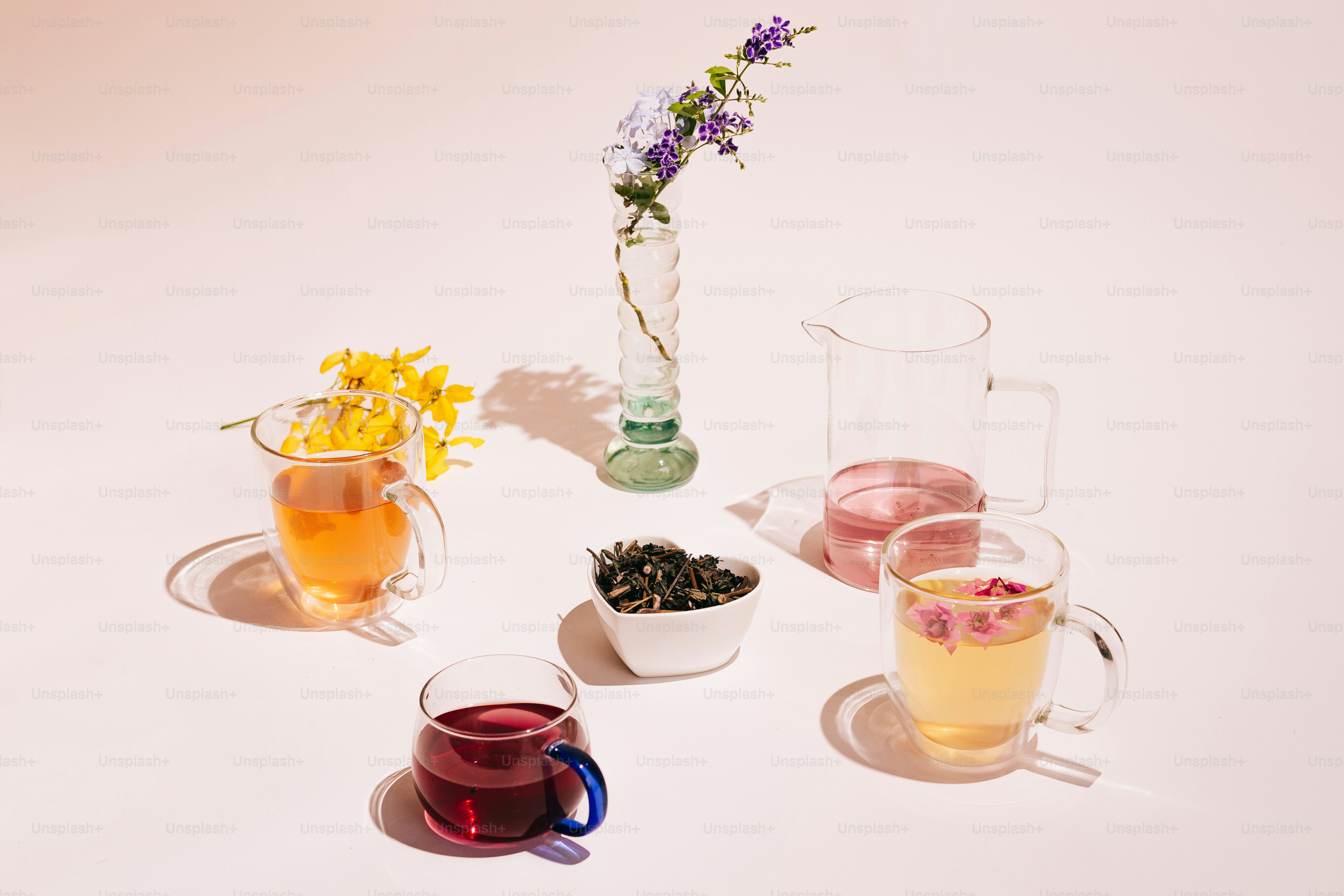 A table topped with cups and vases filled with flowers