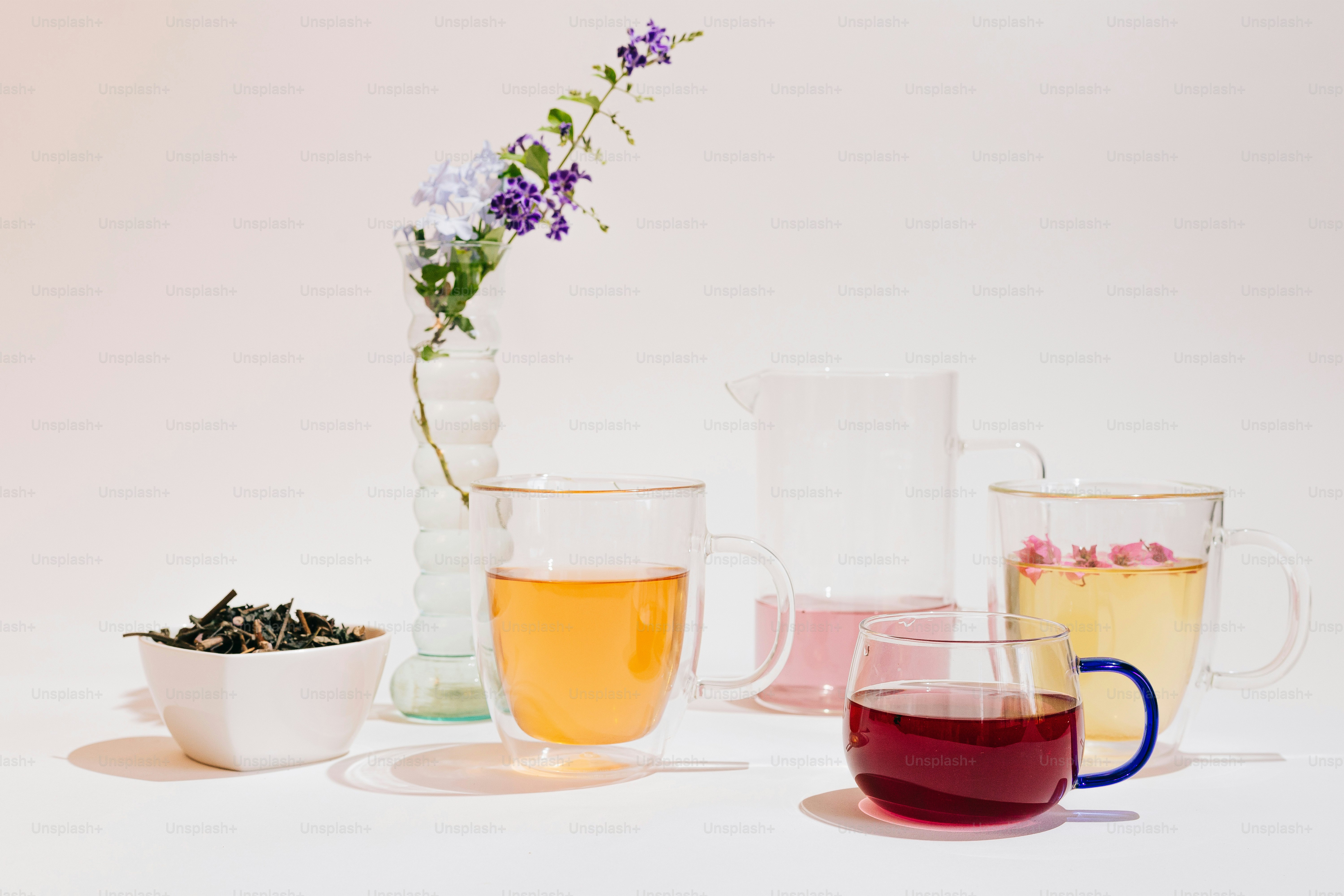 A table topped with glasses filled with different types of tea