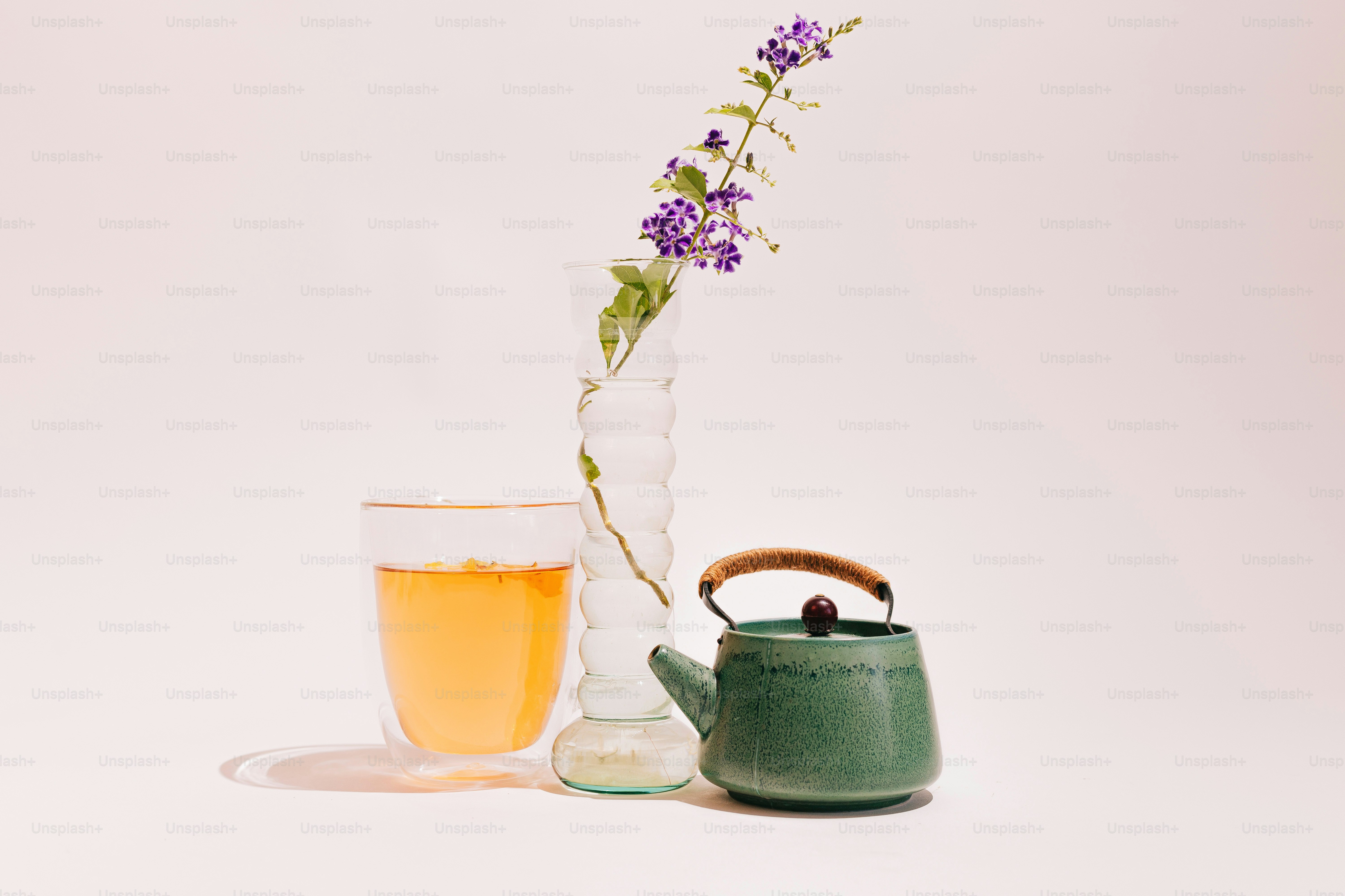 A tea pot and a vase with a flower in it