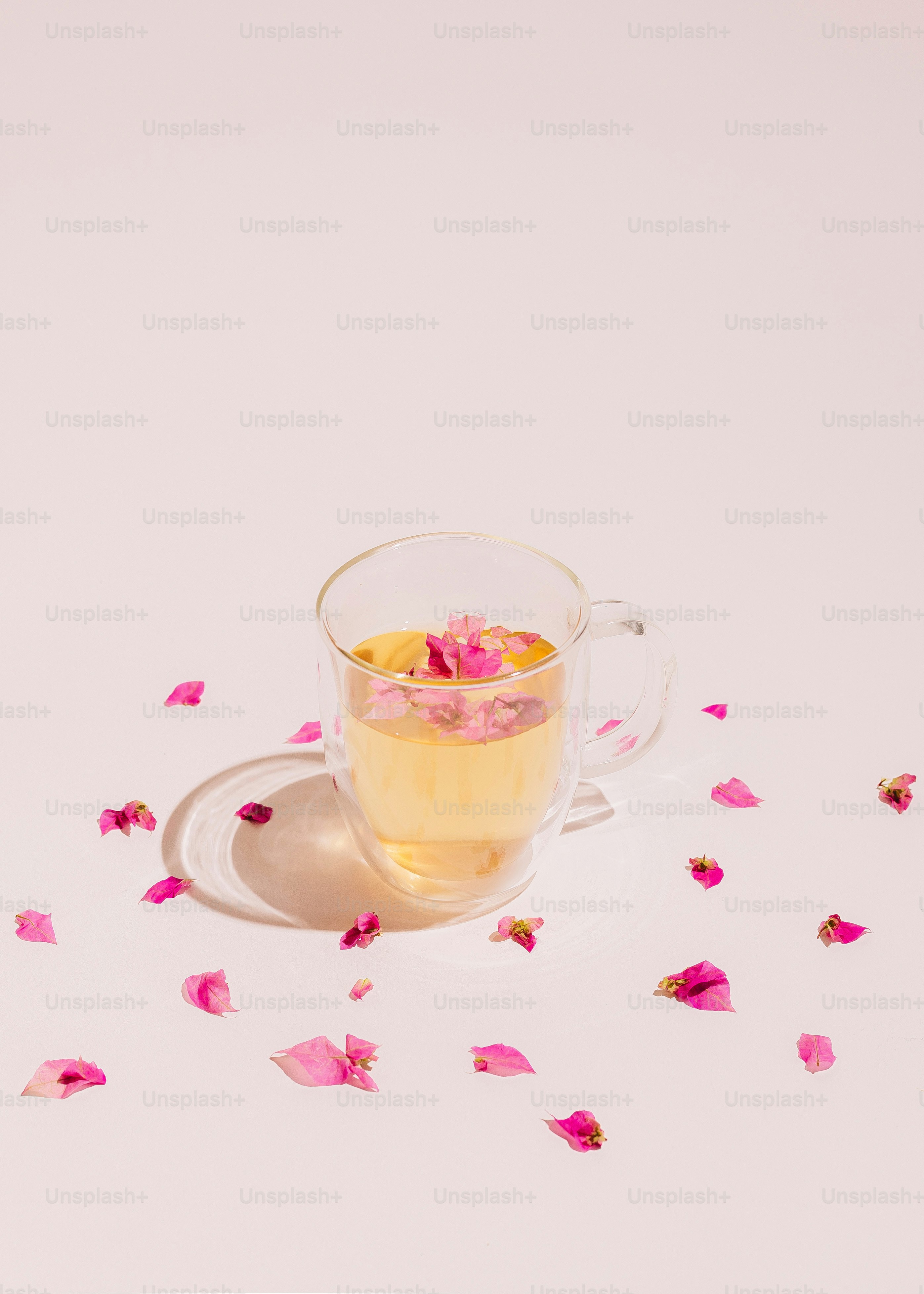 A cup of tea with rose petals on a saucer