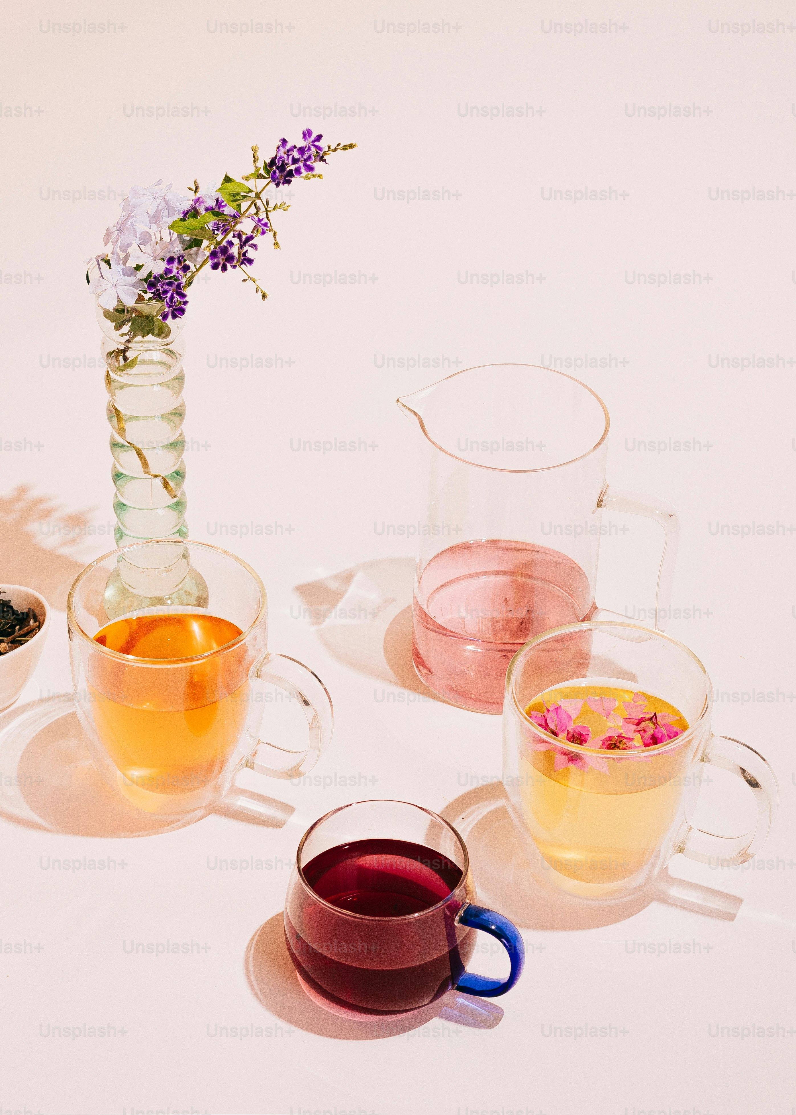 A table topped with glasses of wine and a vase filled with flowers