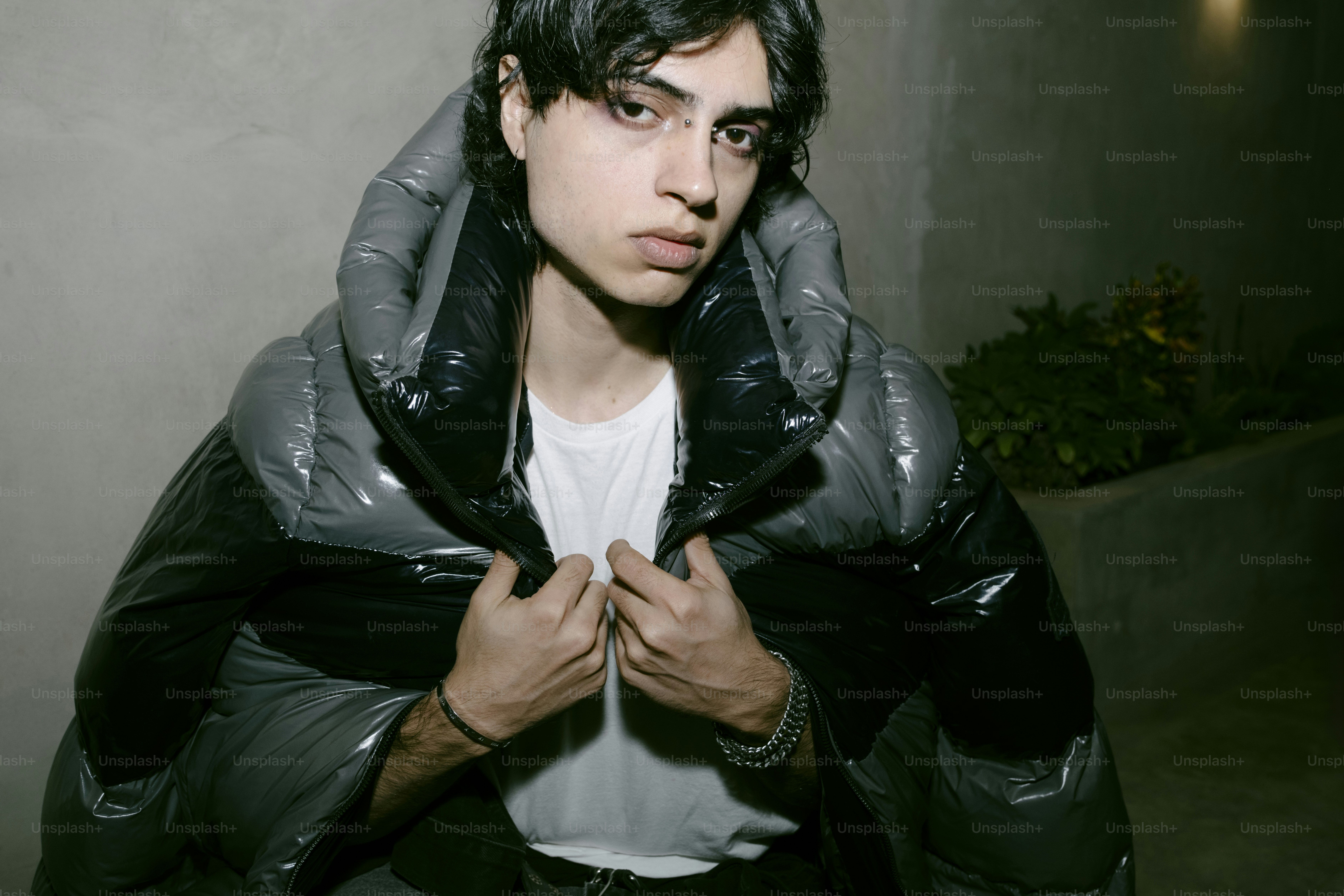 A man wearing a black jacket and a white t - shirt