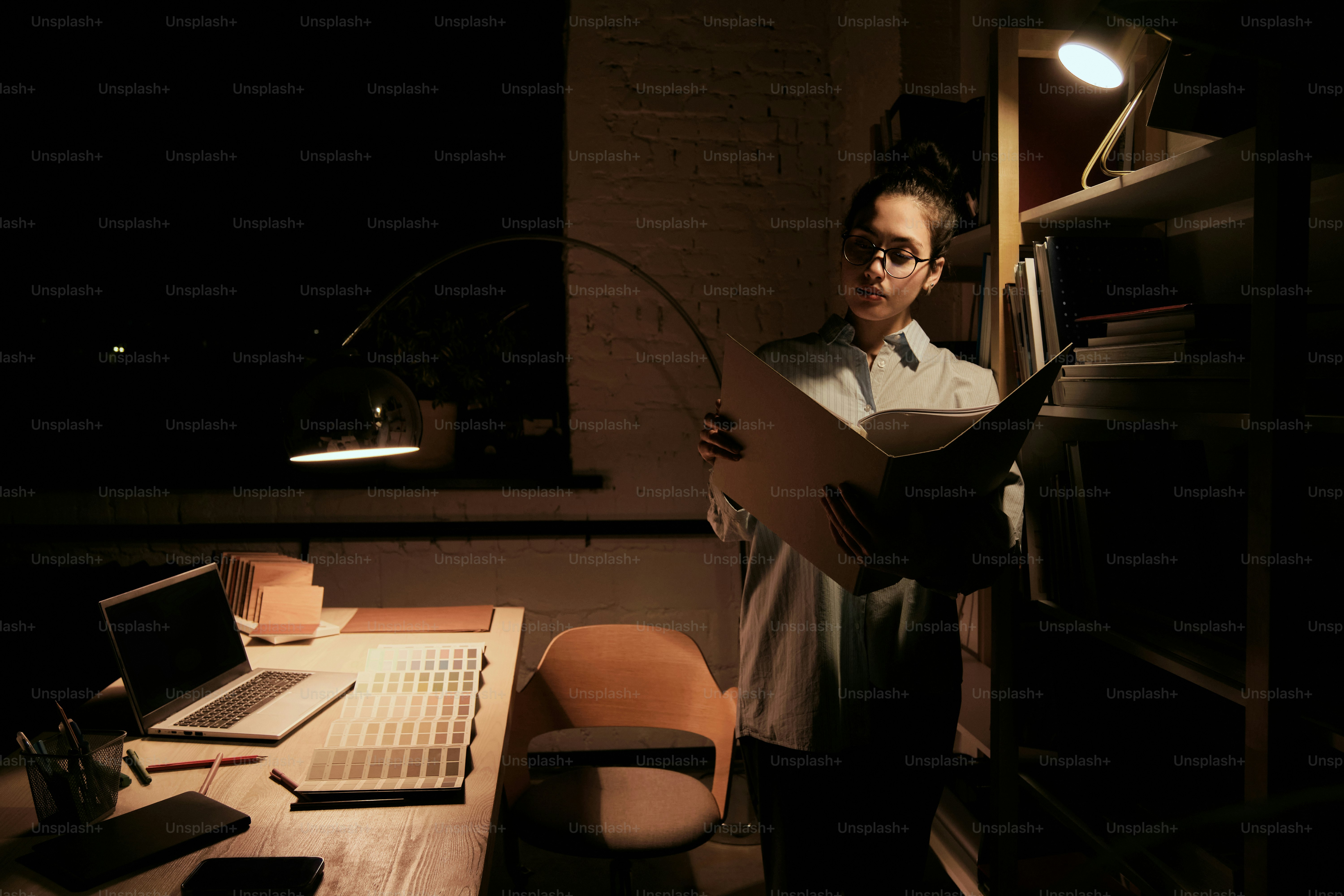 A woman standing in front of a computer in a dark room