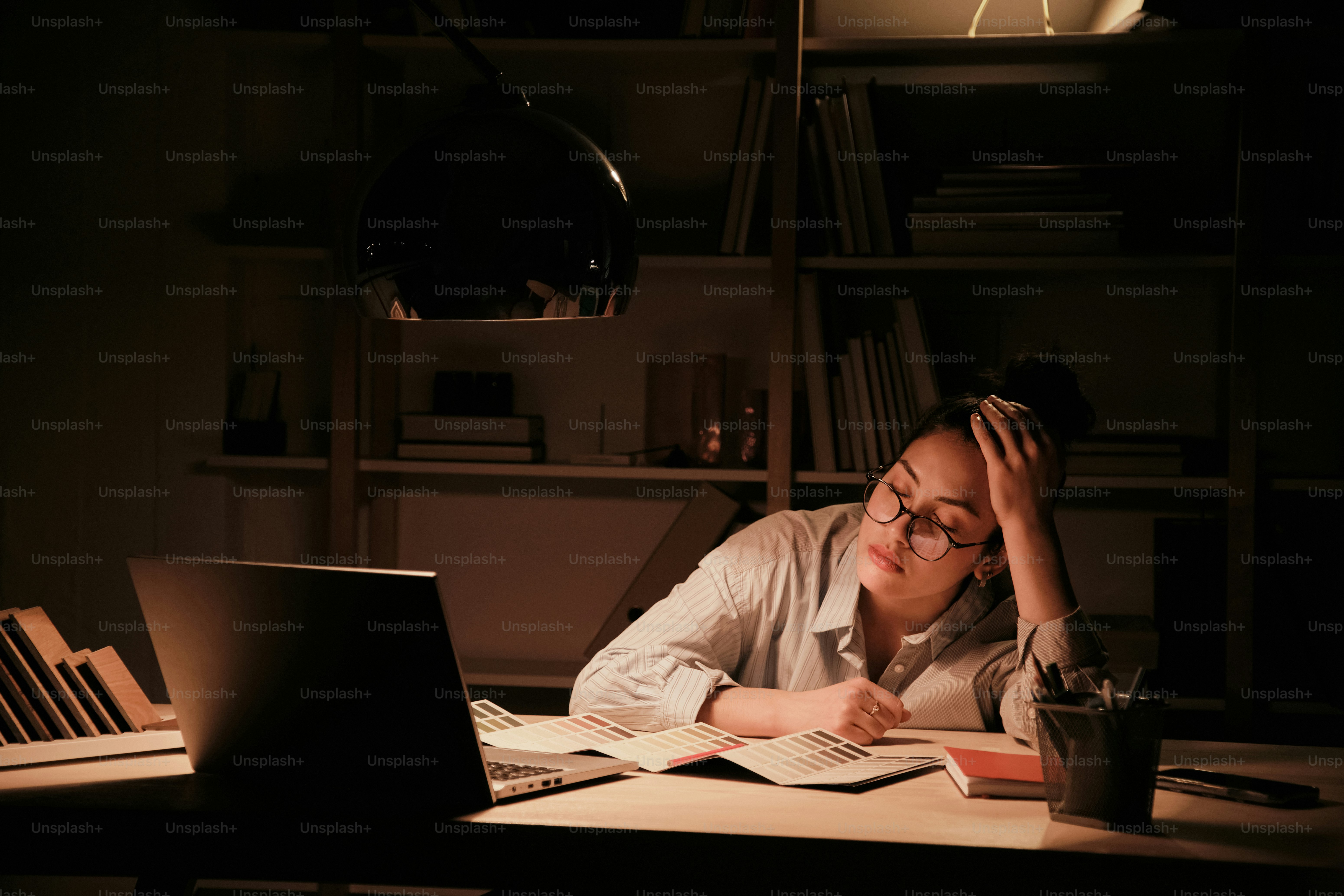 A woman sitting at a desk in front of a laptop computer