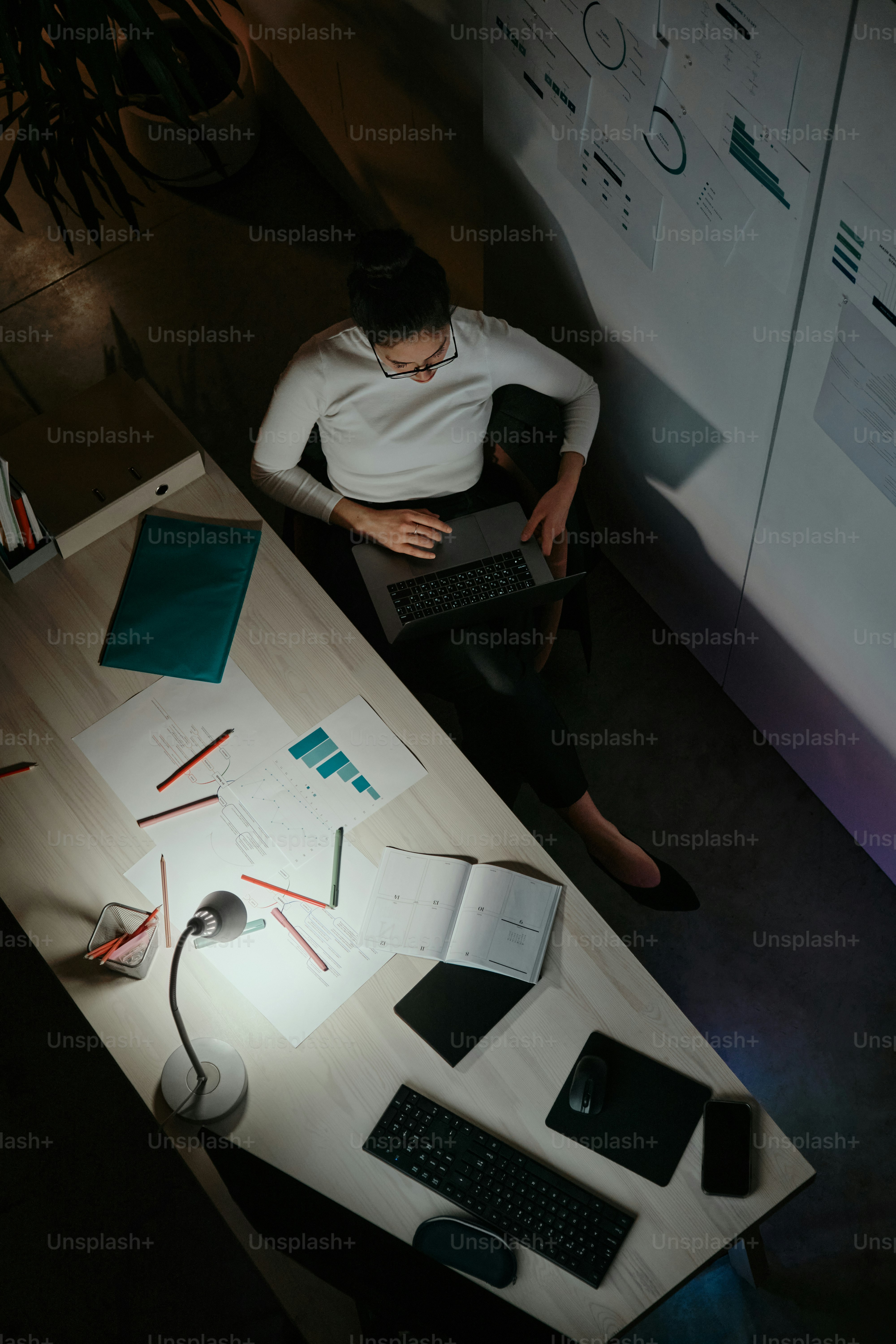 노트북을 들고 책상에 앉아 있는 사람