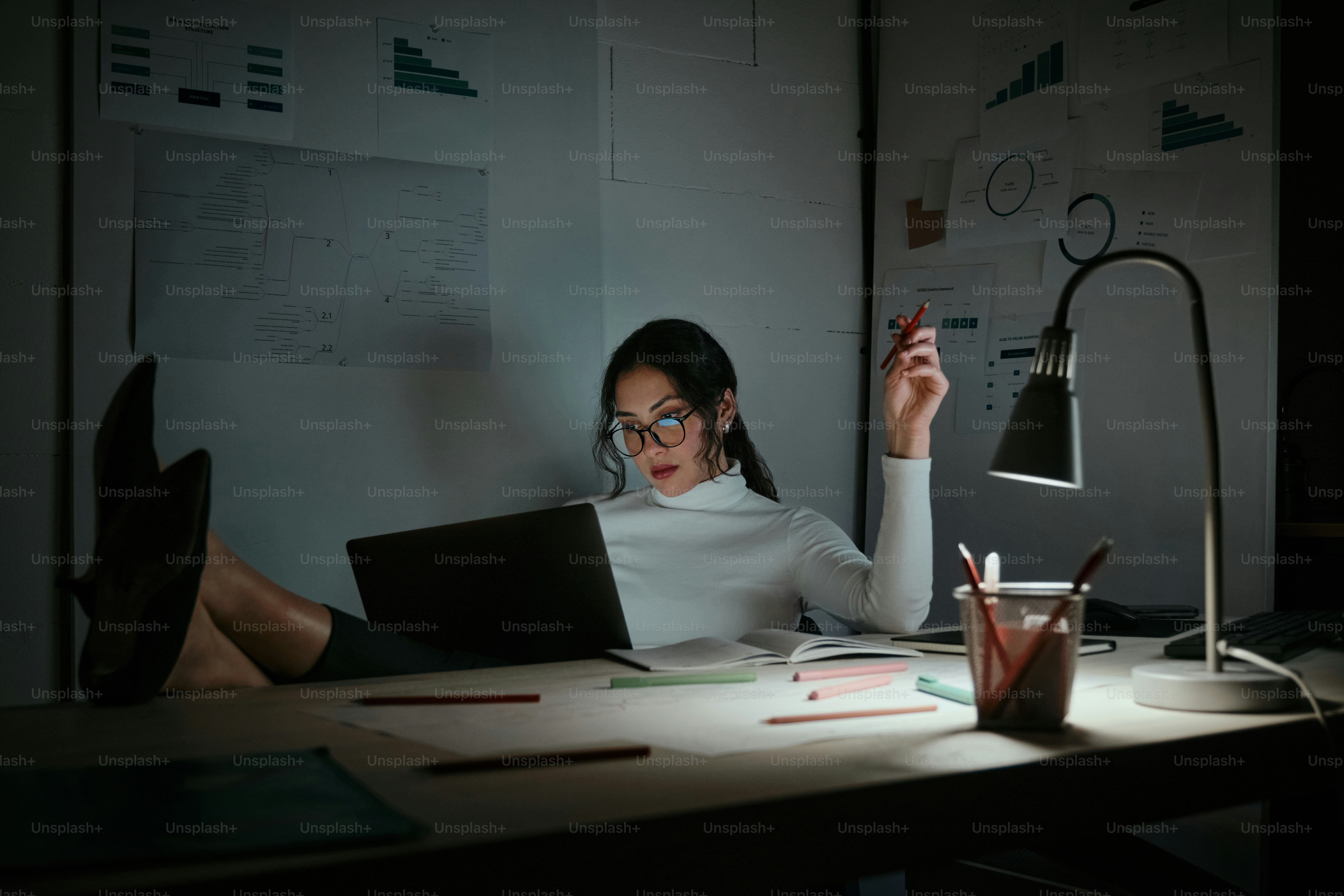 A woman sitting at a desk in front of a laptop computer