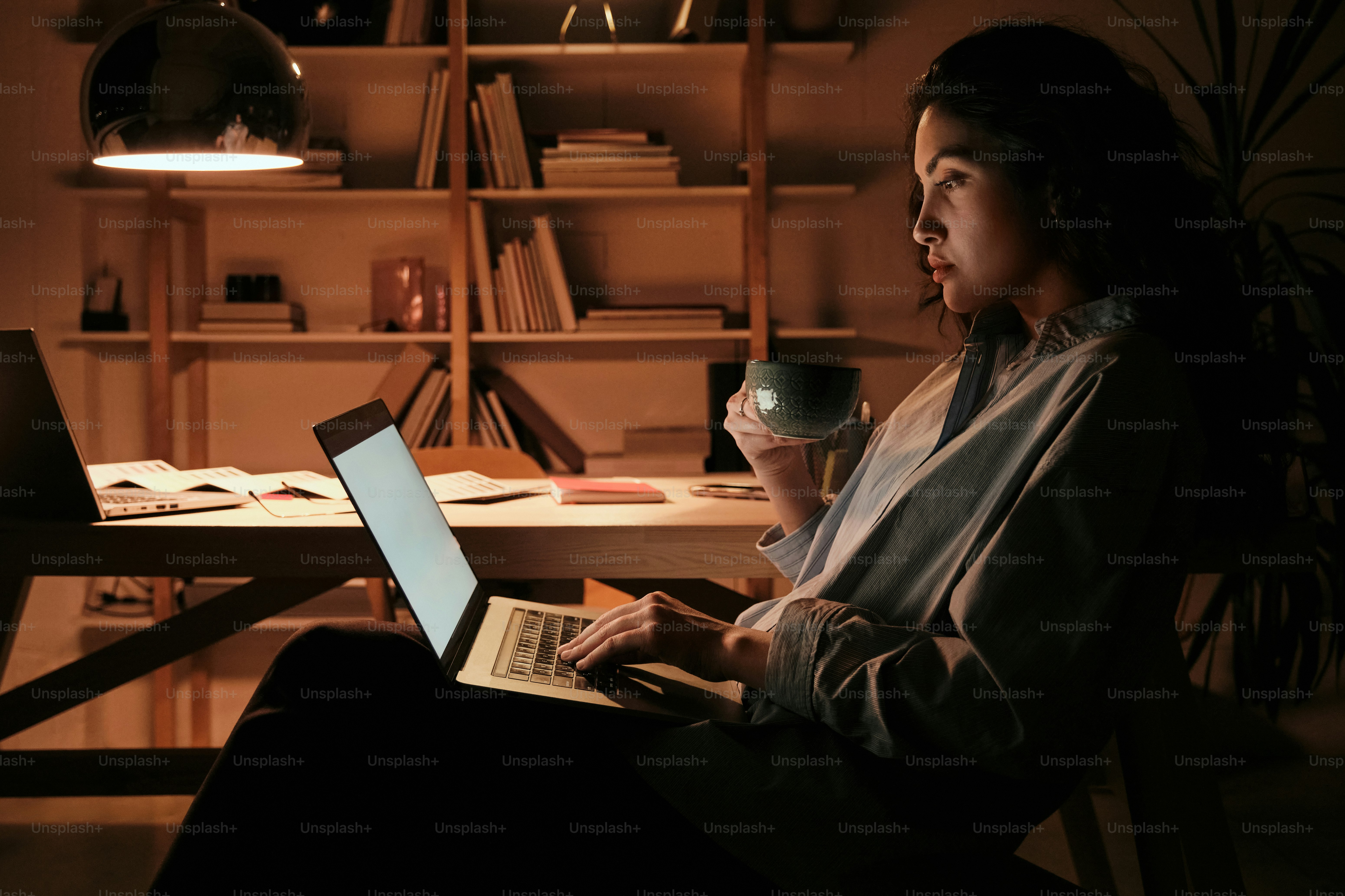 Eine Frau, die auf einem Stuhl sitzt und einen Laptop benutzt