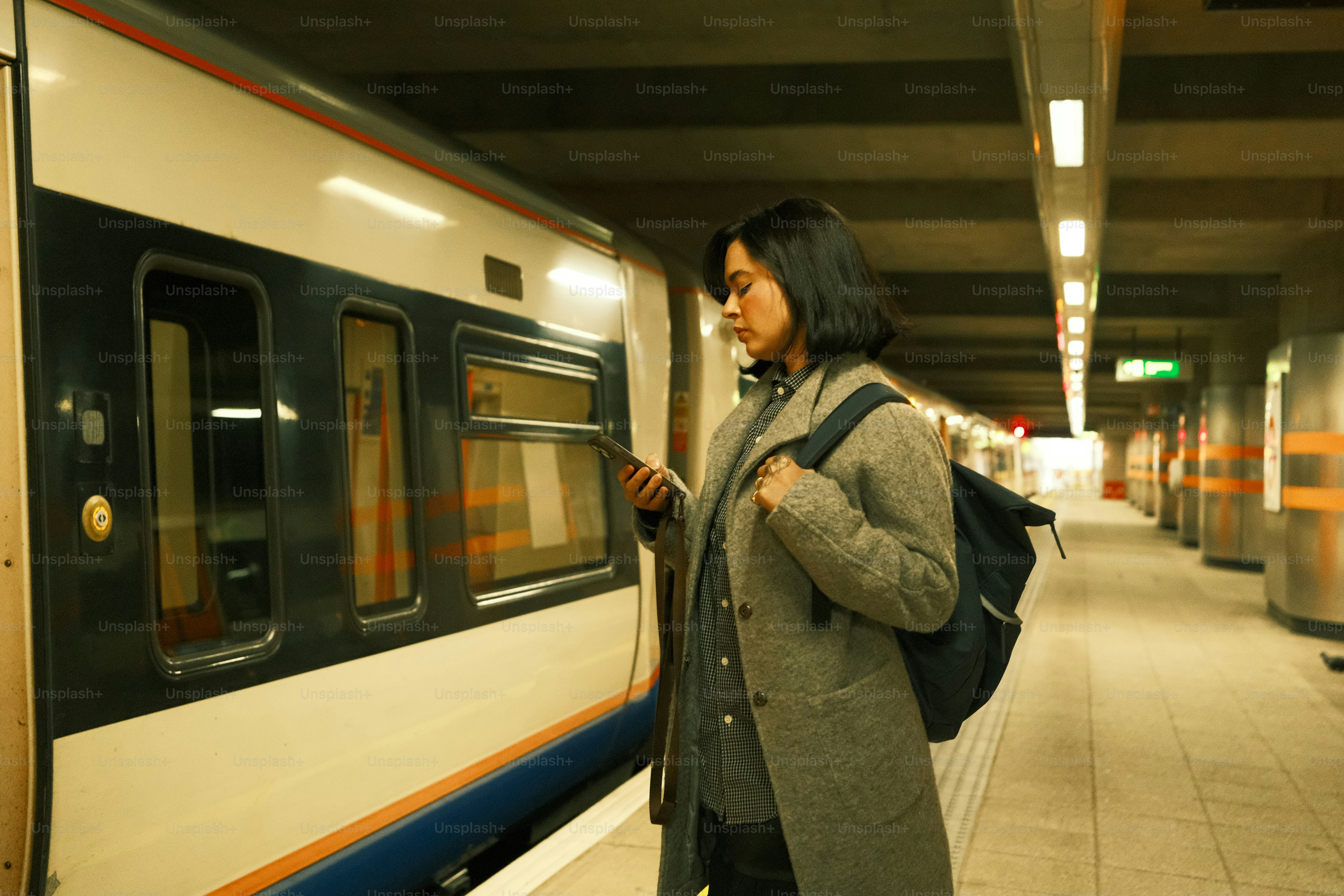 A woman standing next to a train at a train station