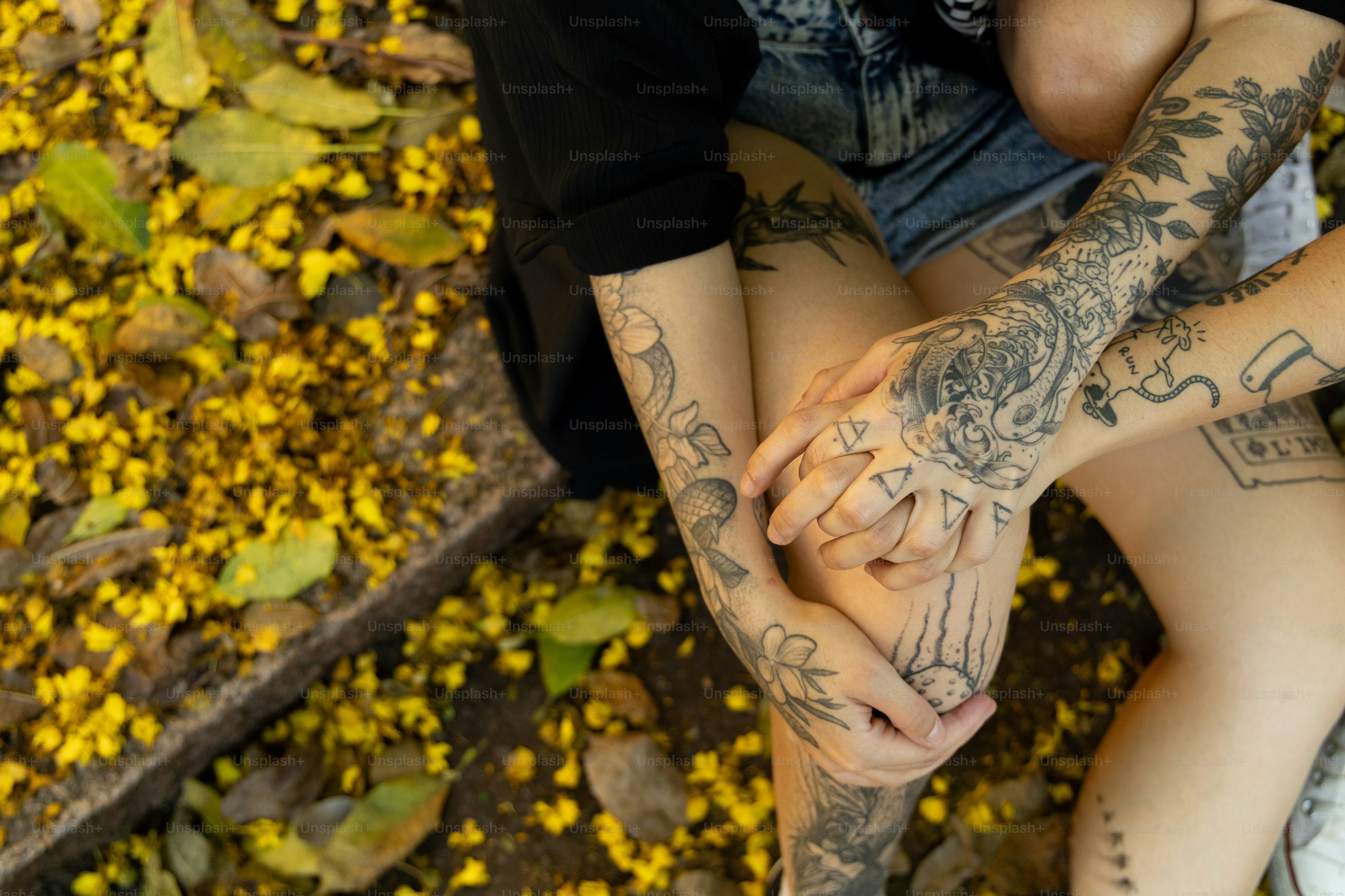 Una donna con tatuaggi seduta per terra