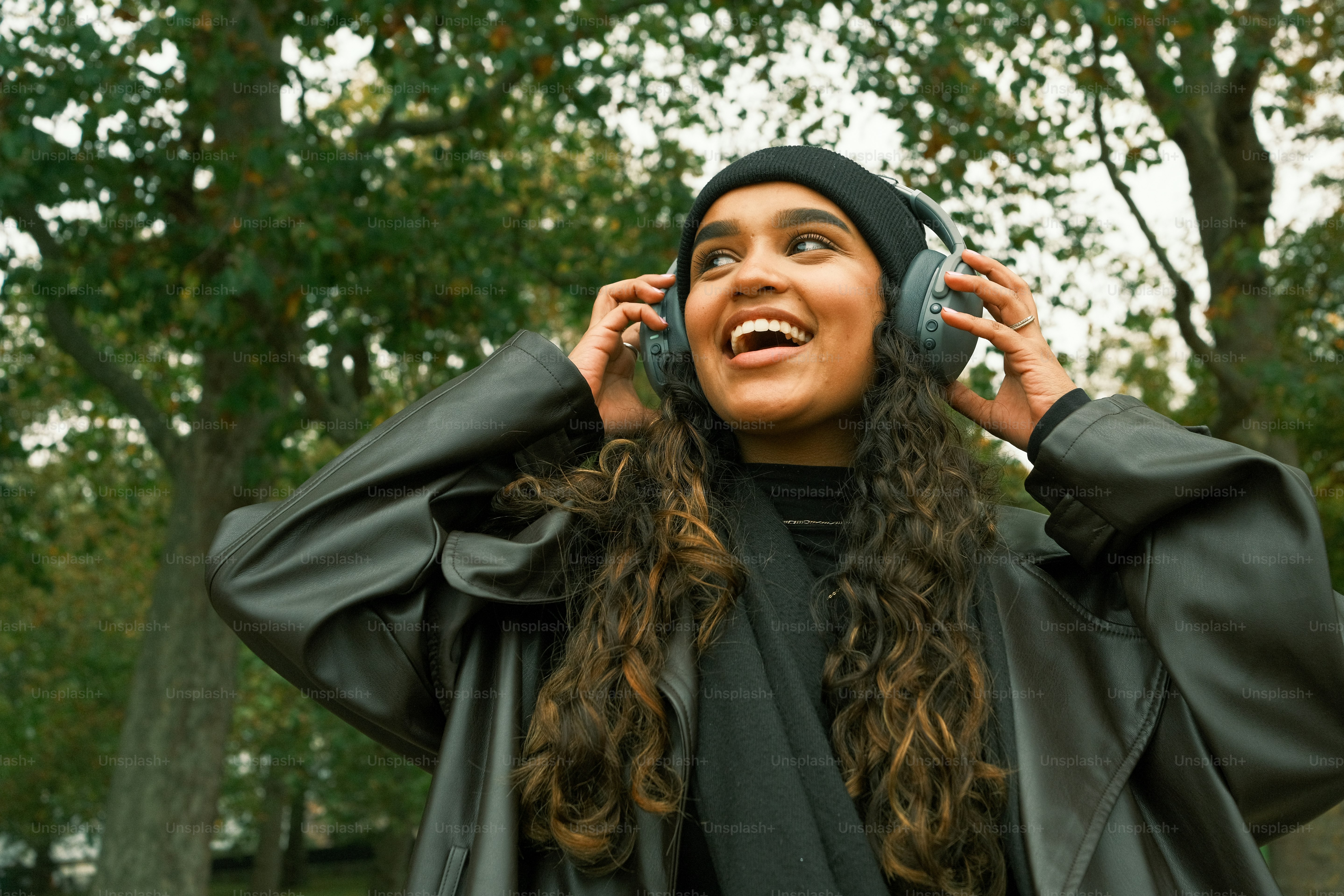 Seorang wanita berjas hitam berbicara di ponsel